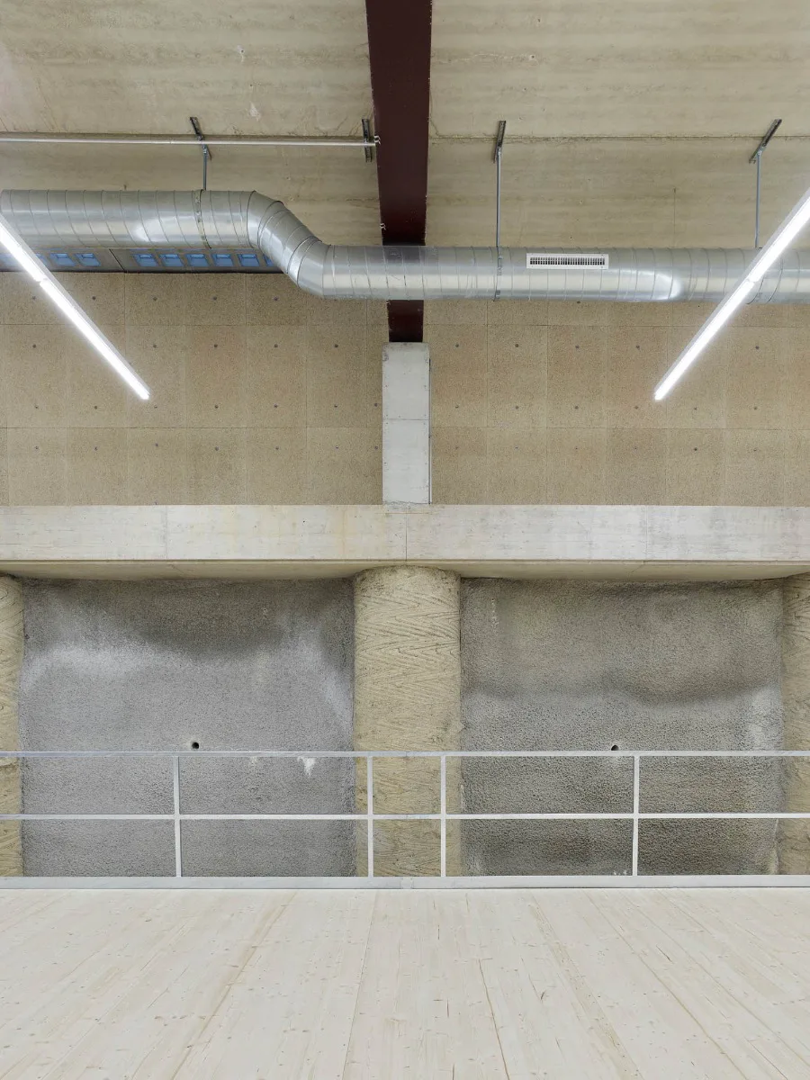 Eine Bohrpfahlwand sichert den Hang und charakterisiert zugleich das Innere der Fahrzeug- und Lagerhalle.