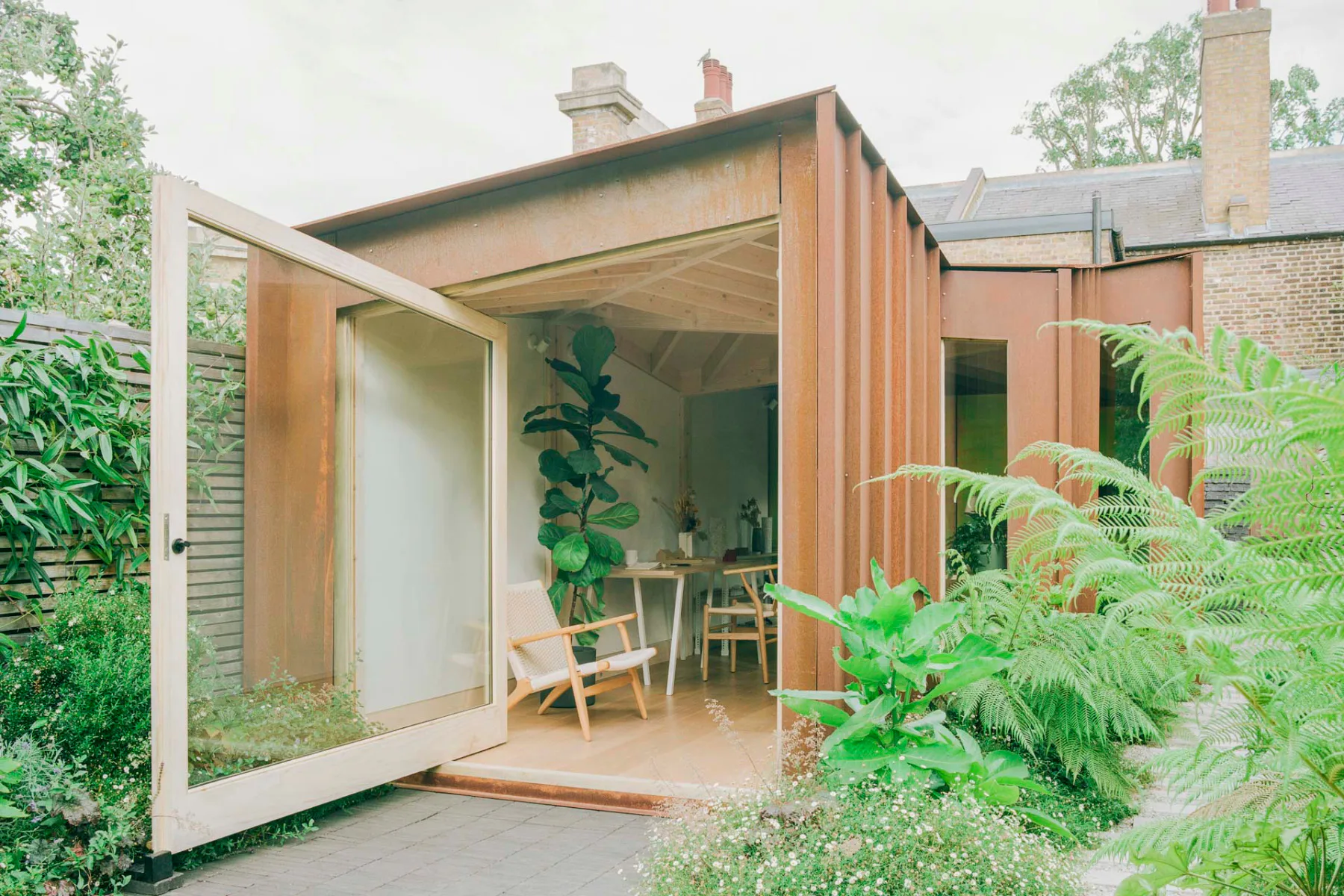 Außen bekleiden das Garden Studio maßgefertigte Cortenstahlplatten.