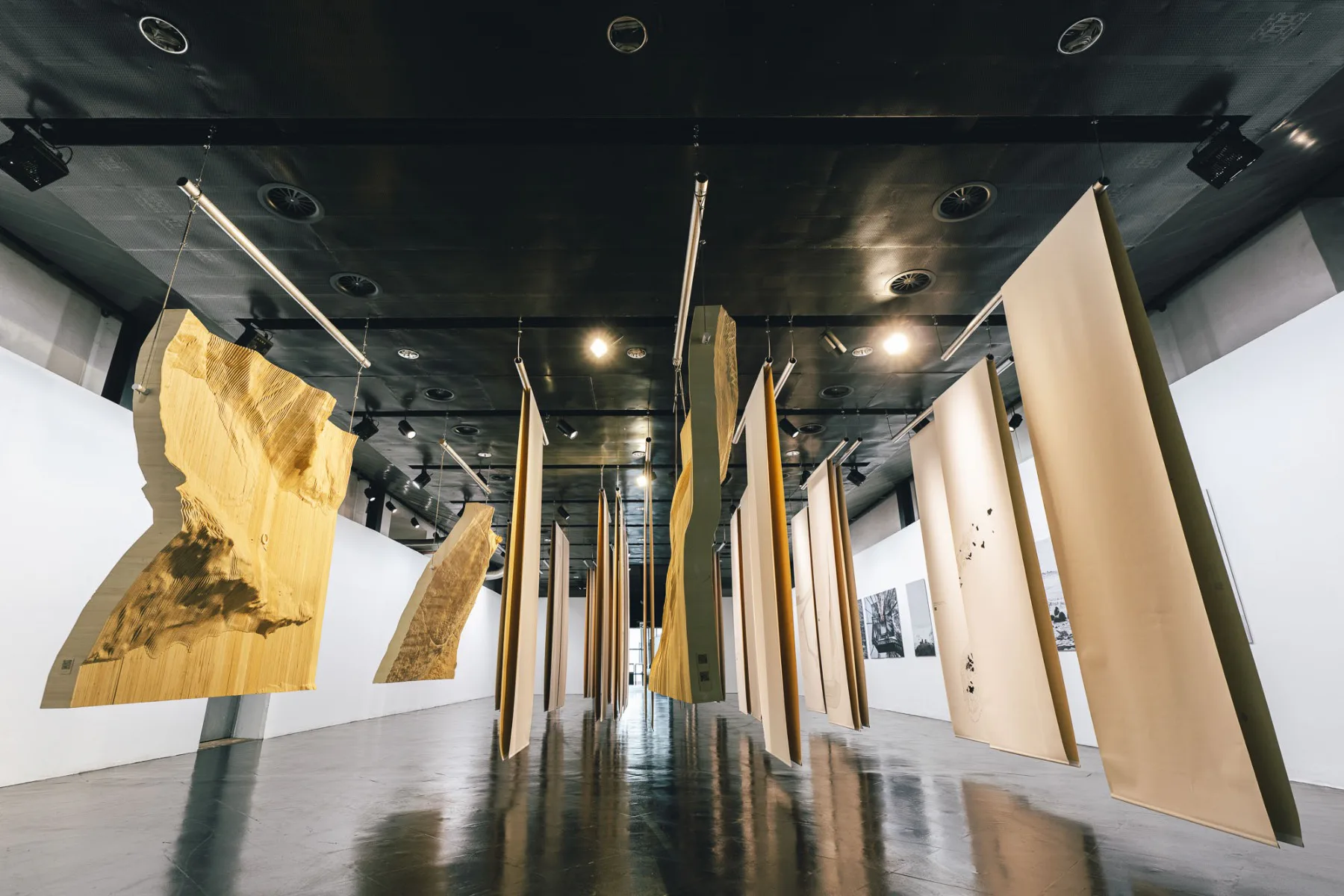 Von der Decke hängende Textilien und Landschaftsmodelle bieten ein besonderes Ausstellungserlebnis.