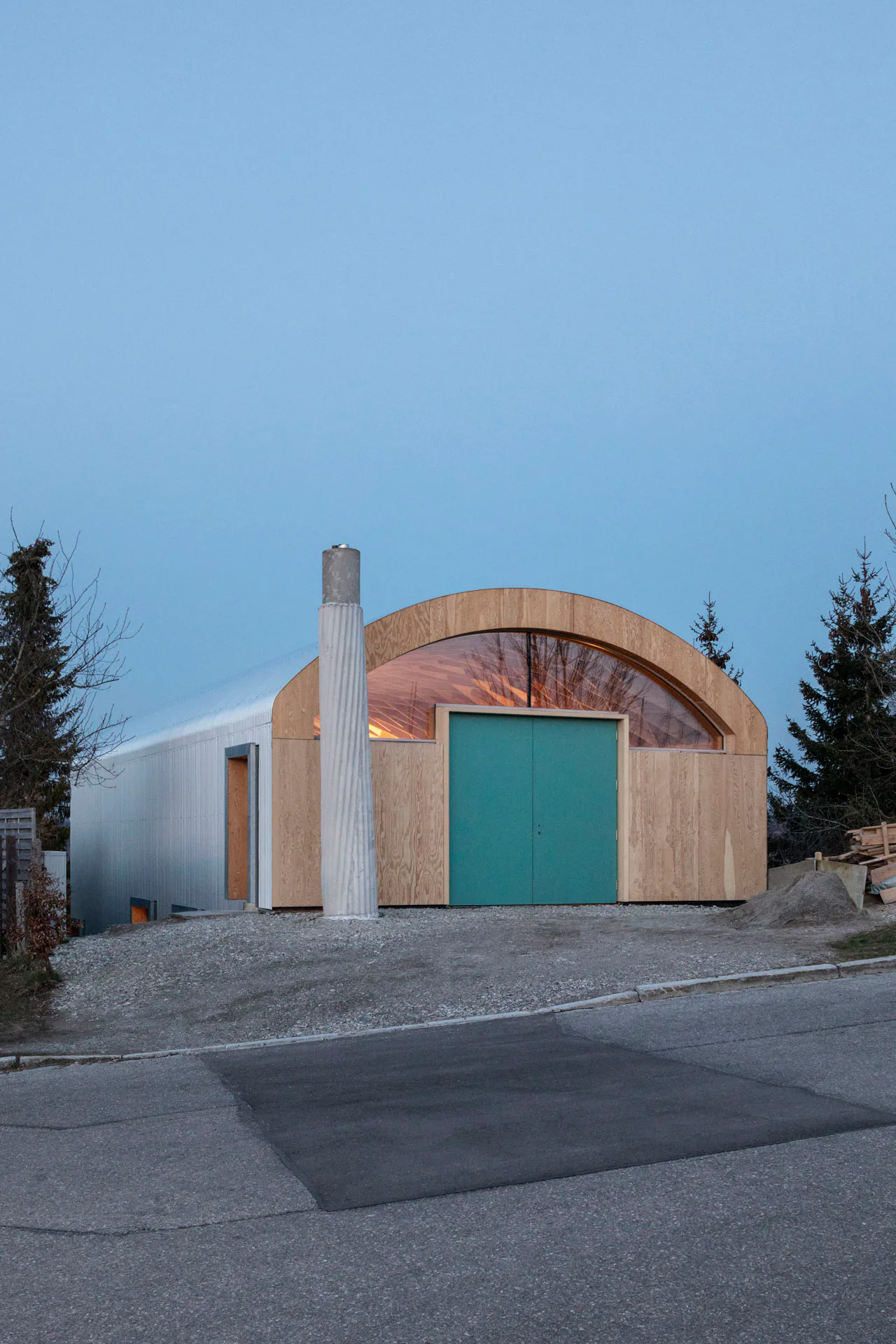 Mit seinem schlichten Äußeren und dem übergroßen Schornstein erinnert das Haus an die Hangars des nahe gelegenen Flugplatzgeländes.