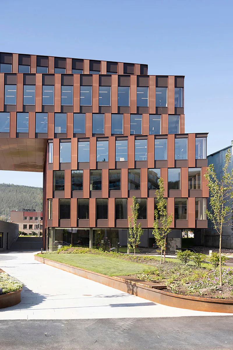 Das Bürogebäude Portalen hat eine rotbraune Fassade aus abwechselnd transparenten Verglasungen und geschlossenen Verbundglaspaneelen.