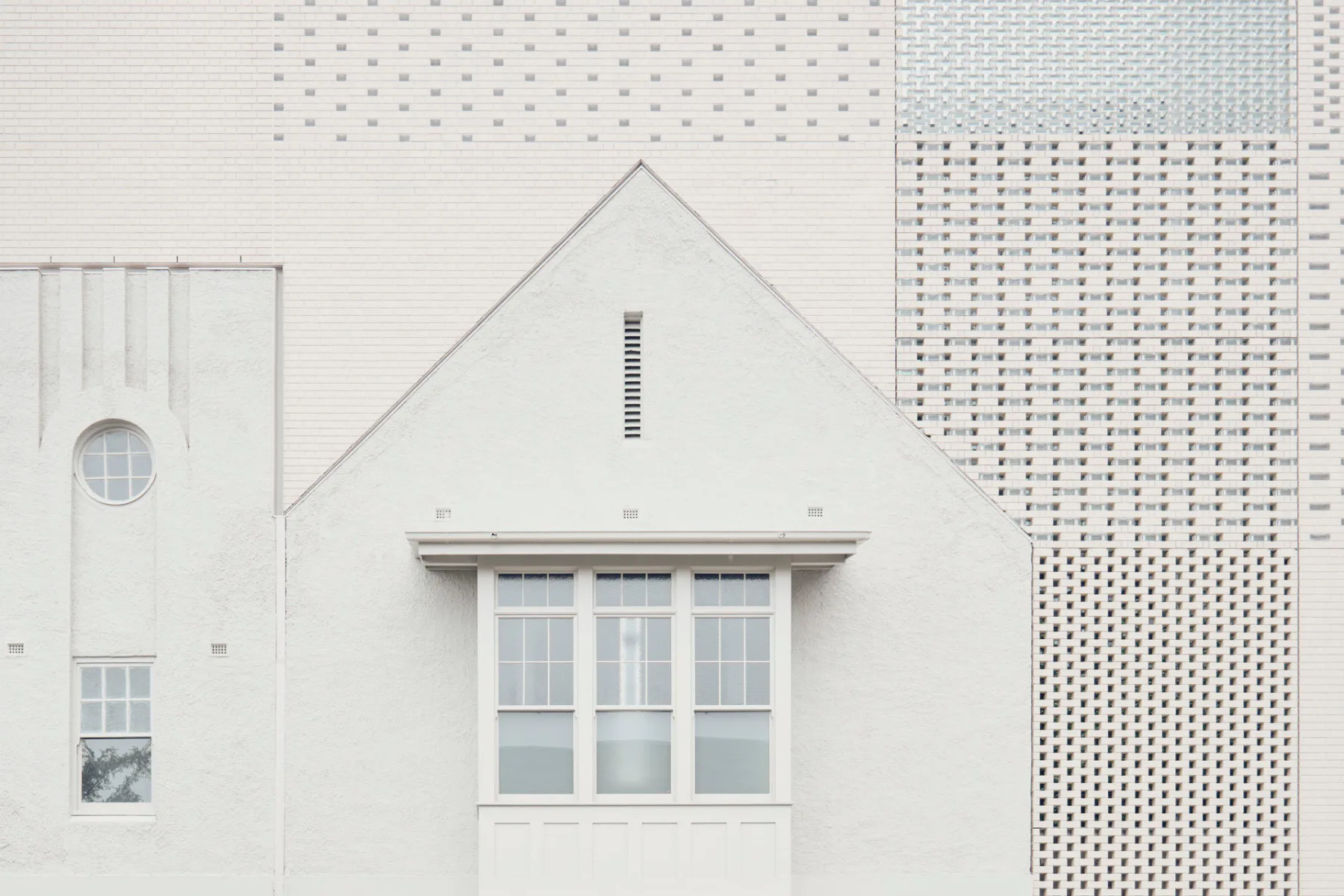 Ein historisches Erkerfenster und eine mit Glas verschlossene Bogentür an der Ecke sind die einzigen größeren Öffnungen in der Straßenfassade.