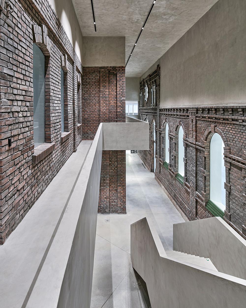 Der ehemalige Schlachthof besteht aus vier einzelnen Gebäudeteilen. Im Atrium, das vom wieder aufgebauten Gebäudeteil in den Bestand führt, ist das noch zu erkennen. Die Sichtziegelfassaden, jetzt im Inneren, sind erhalten geblieben.