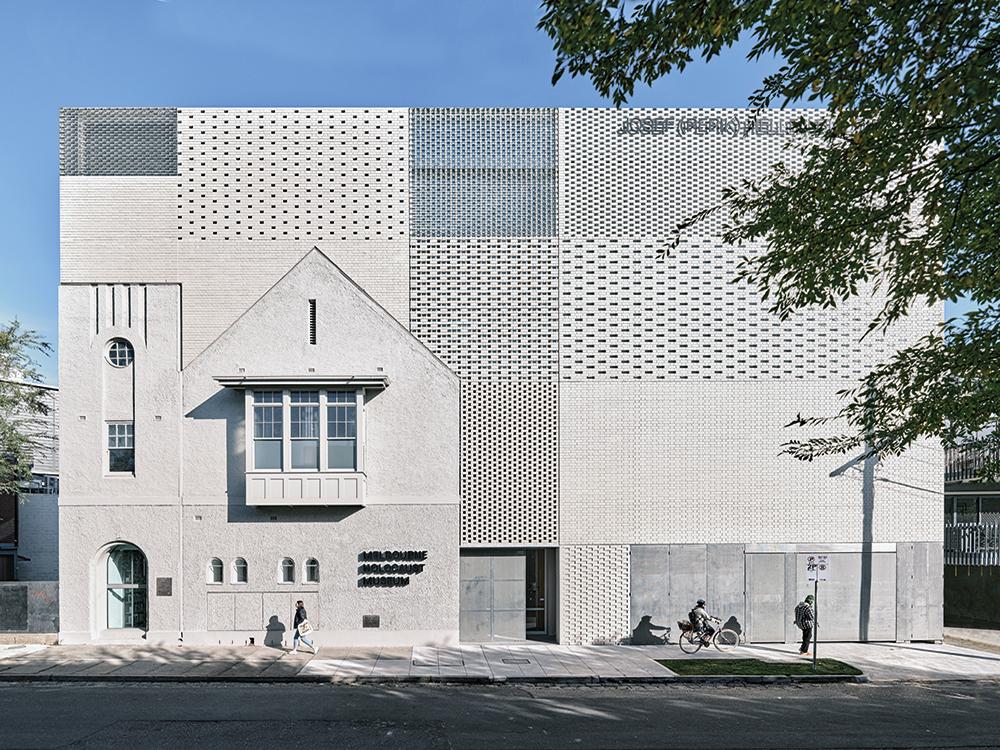 Neun unterschiedliche Mauerwerksverbände aus grauen und gläsernen Ziegeln gliedern die Straßenfassade. Darin wurde auch der Giebel des Vorgängerbaus integriert.