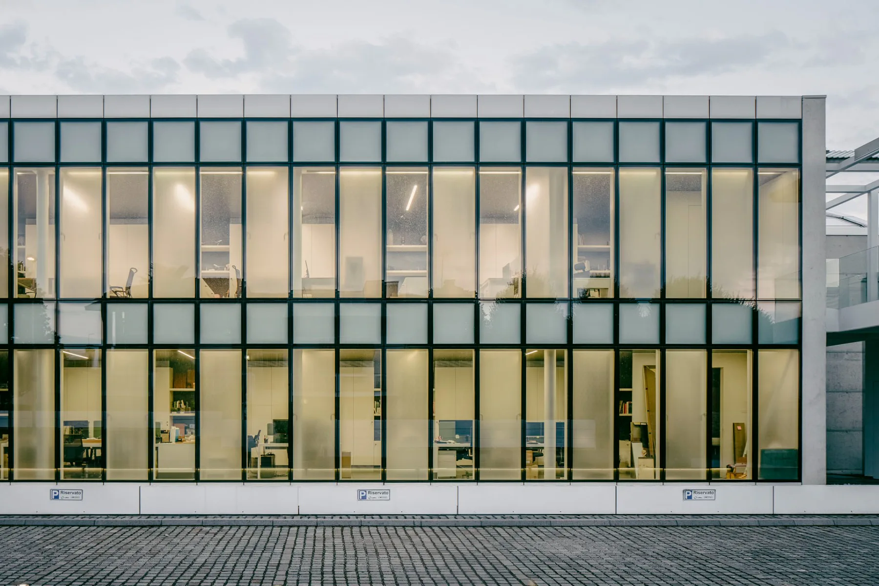 Richtung Vorplatz öffnet sich der Firmensitz mit einer zweigeschossigen Pfosten-Riegel-Fassade.