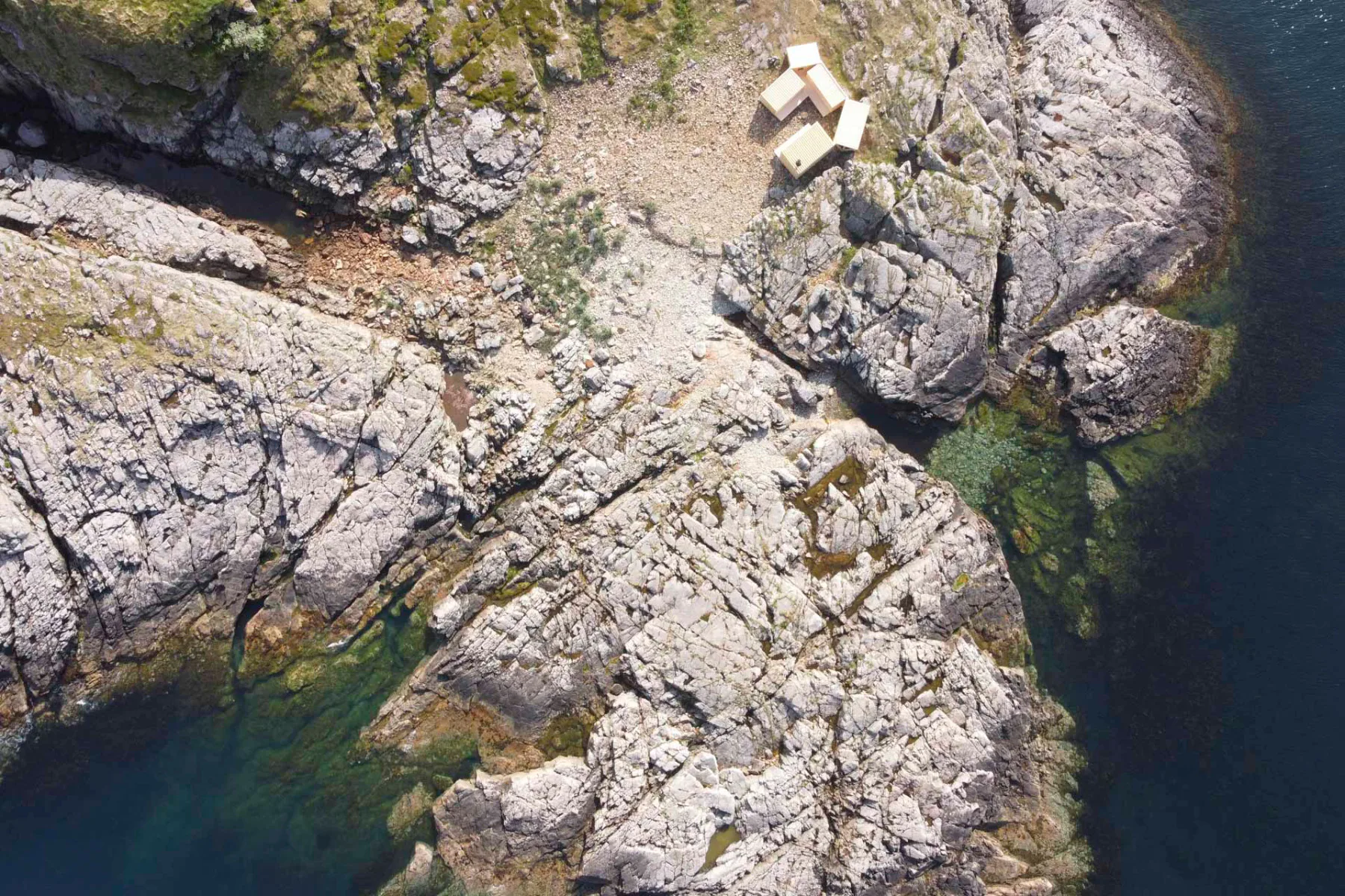Die deutlich höheren Felsen und die Anordnung der Baukörper schützen die Übernachtungsgäste vor Wind und Wetter.