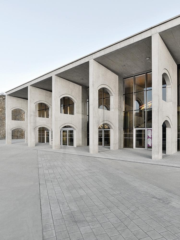 Schroff ragt das Kulturzentrum vor den hohen Stützmauern empor, die das ehemalige Stahlwerksgelände umgeben.