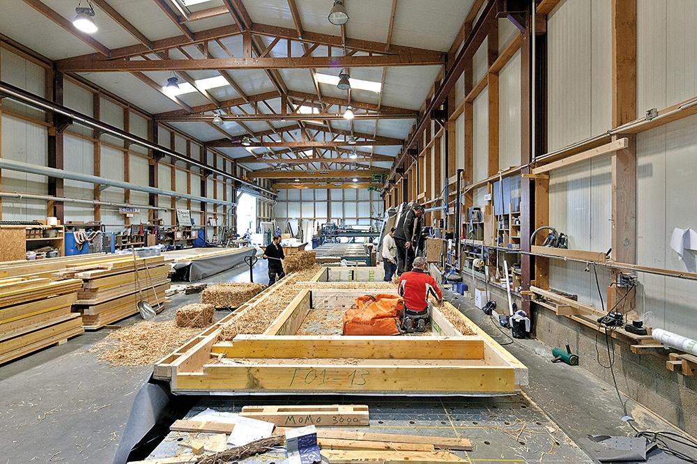 Die geschosshohen, mit Strohballen gefüllten Holztafelelemente der Fassaden wurden in einer Werkshalle vorgefertigt. Das Stroh stammt aus der Region rund um Paris.