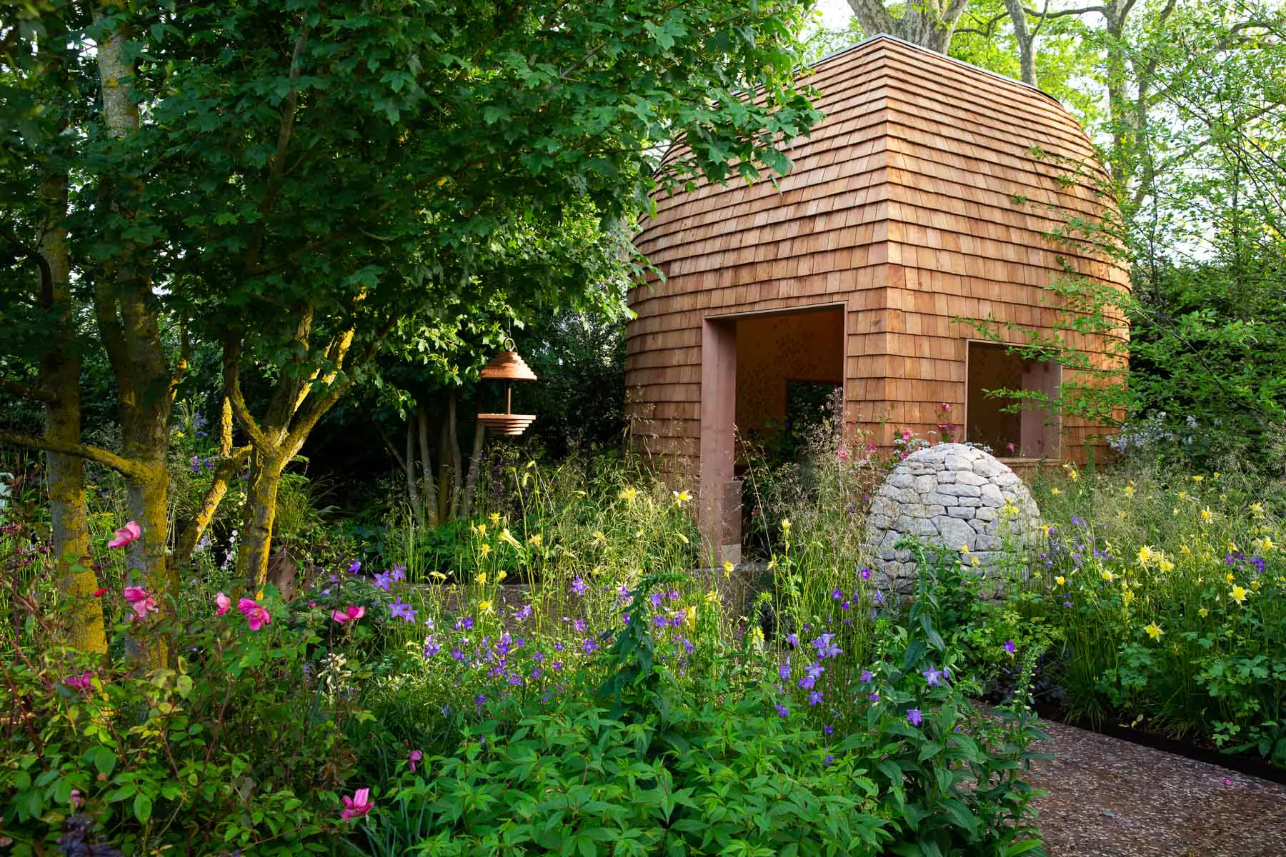 Der kleine, kapselartige Gartenpavillon ist als Holzbau konstruiert.