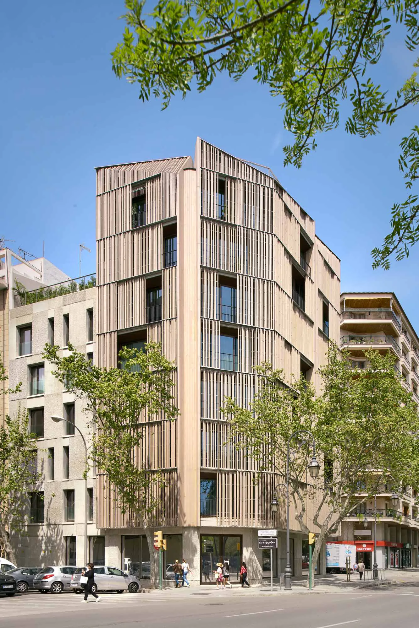 Brise-Soleils aus Holzlatten und vertikal strukturierte Oberflächen aus Glasfaserbeton binden den Neubau in seine urbane und doch grüne Umgebung ein.