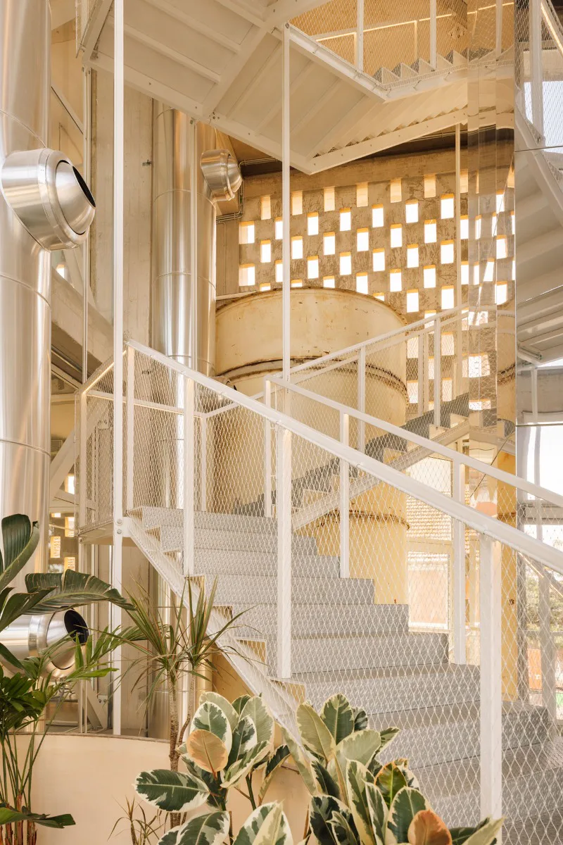 Weiße Treppen aus Stahl ergänzen die industrielle Atmosphäre der ehemaligen Fabrik.