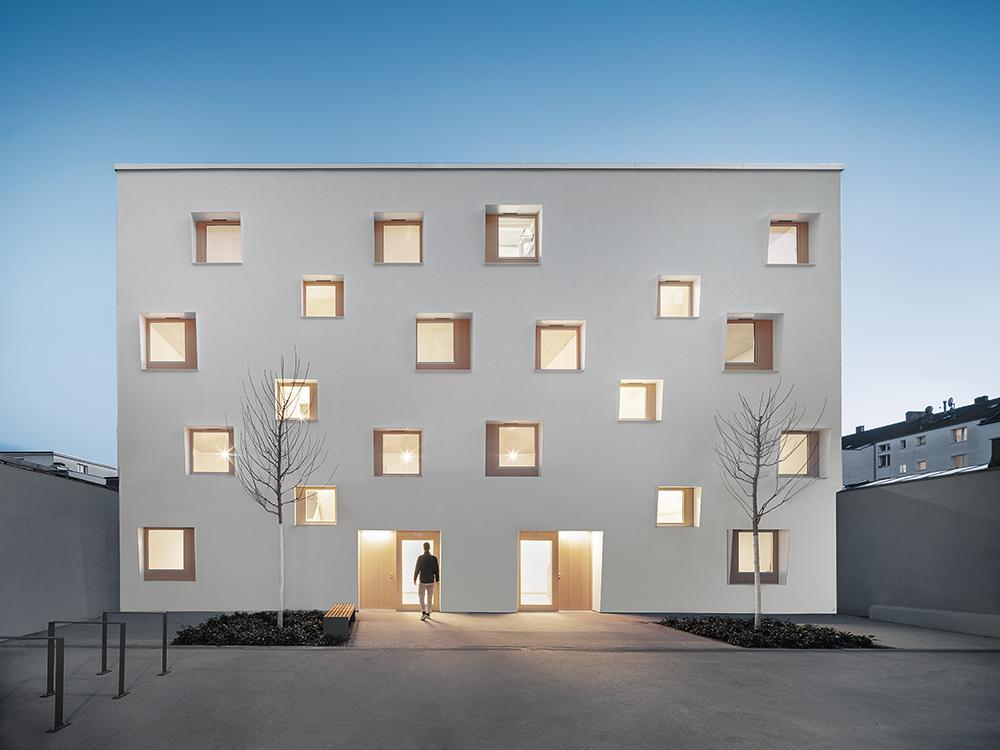 Die Gestaltung der Nordfassade wirkt wie ein abstraktes Bild vis-à-vis der Balkone des Altbaus. Asymmetrische Fensterrahmen verstärken die Tiefenwirkung.