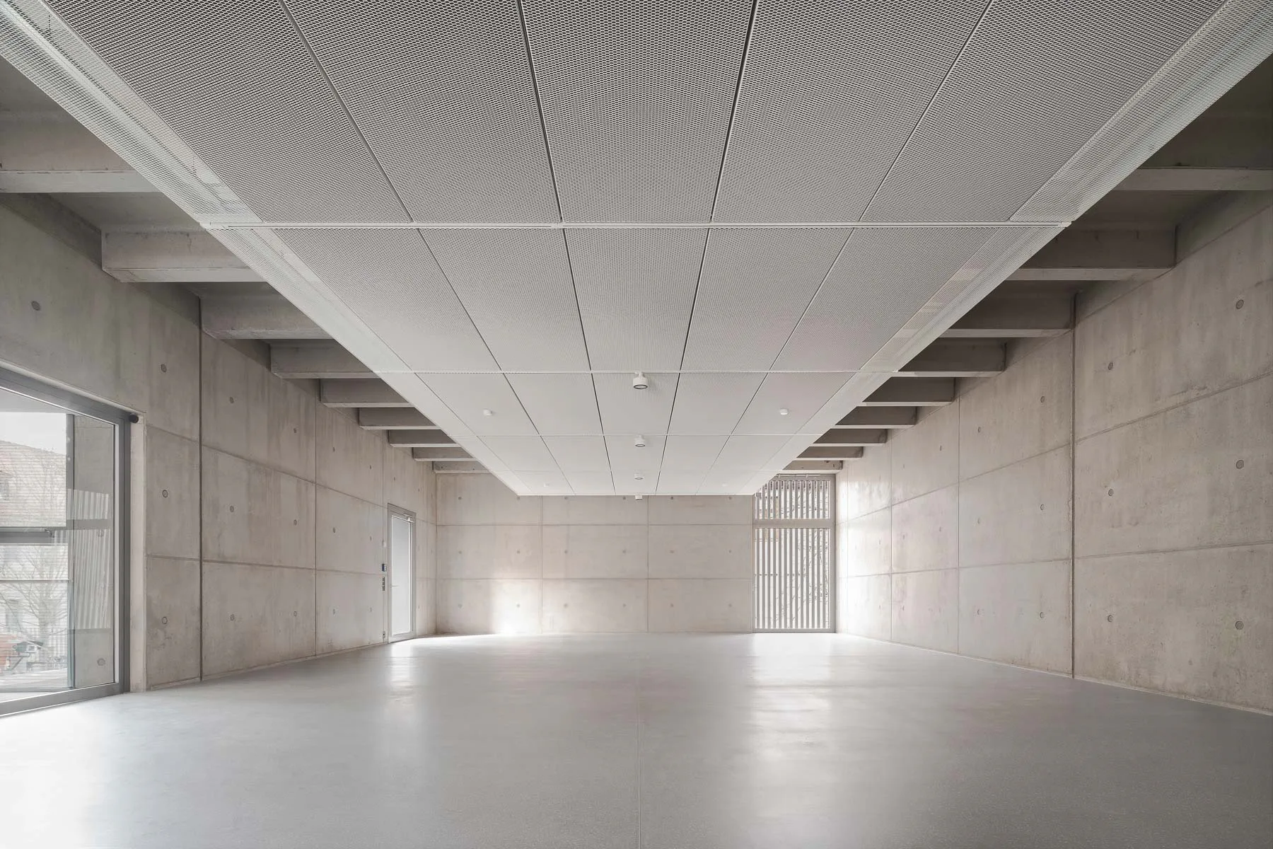 Die einfache, rohe Stahlbetonkonstruktion haben die Architekten in den Obergeschossen sichtbar belassen.