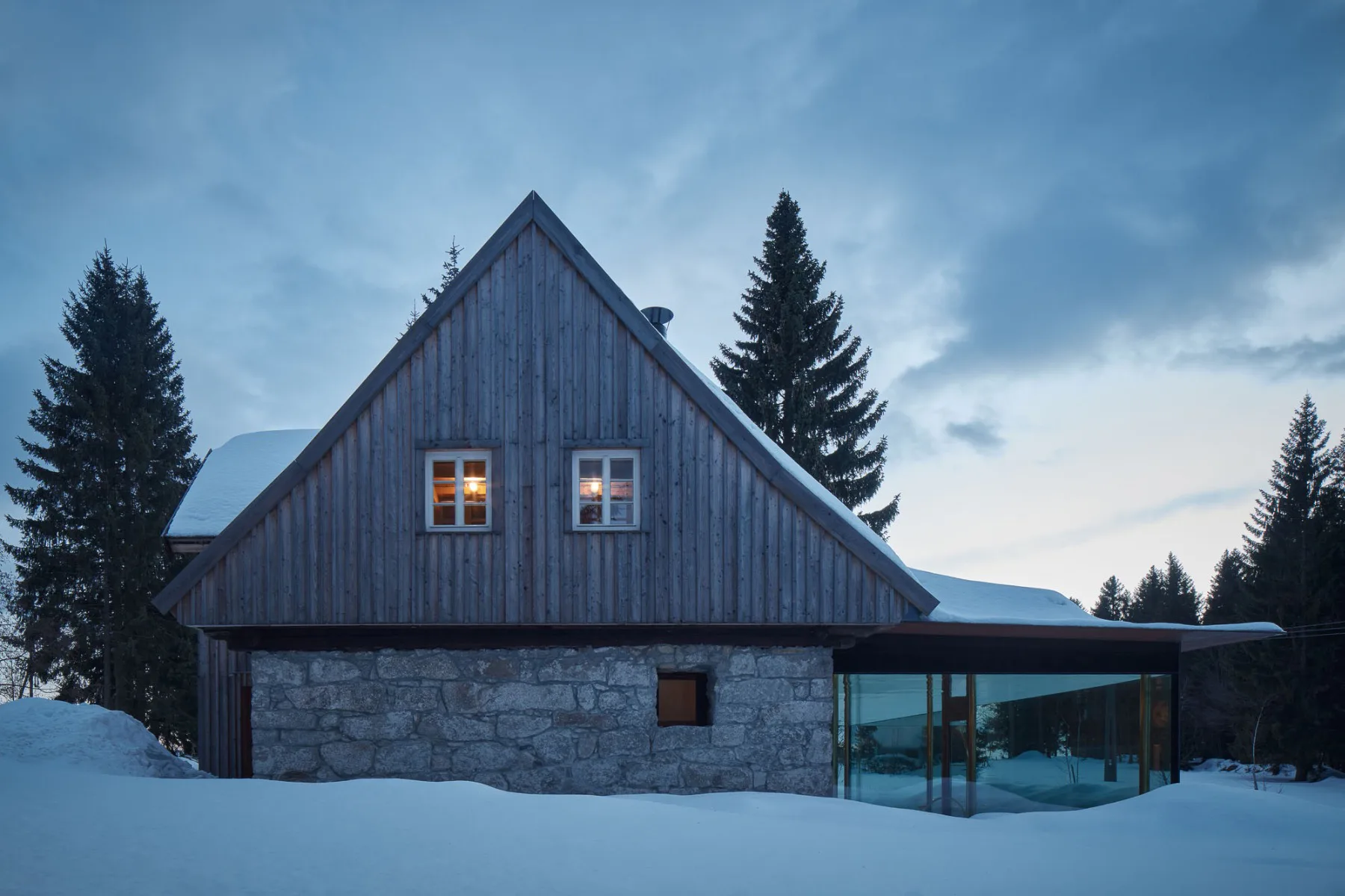 Die straßenseitige Fassade präsentiert sich unauffällig und ortstypisch mit Holz und Granit.
