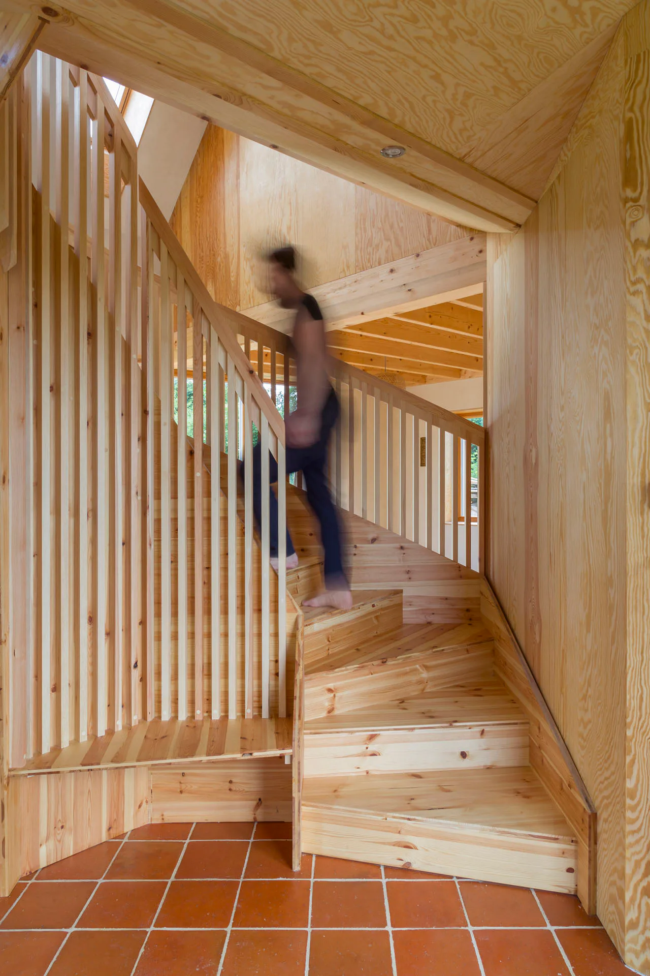 Die segmentierte Treppe aus Holz bildet das zentrale Element im Erdgeschoss.
