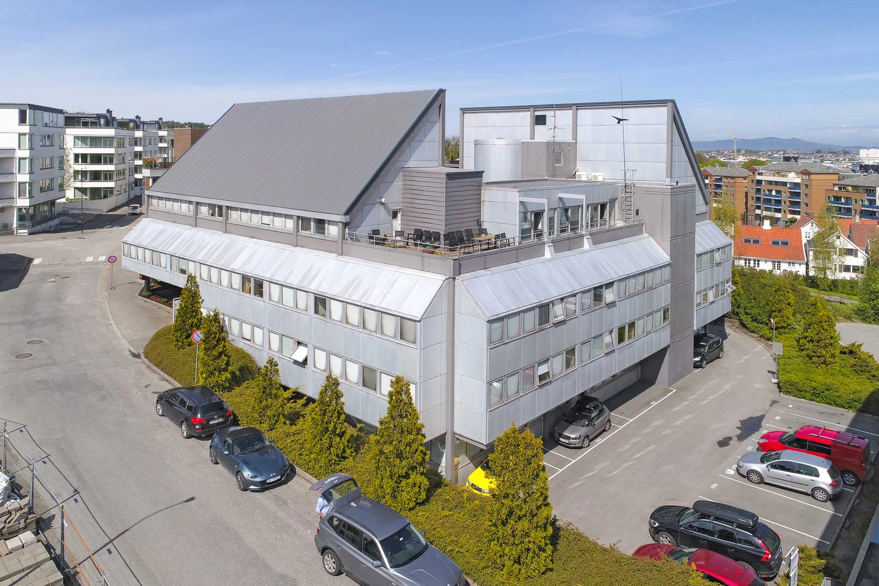 Das Bürogebäude vor dem Umbau: ein typischer Bau aus den späten 1970er-Jahren mit steil aufragenden Pultdächern und erkerartig auskragenden Fensterfronten.