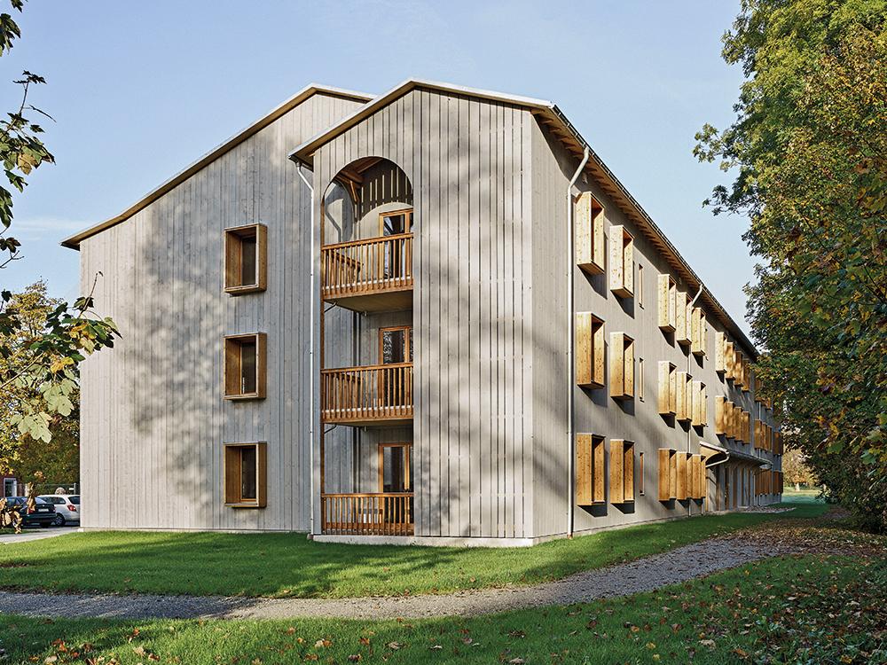 This apartment block presents two very different facades to its surroundings. To the south-west it opens with balconies, while the north-east front with its striking, boxlike window surrounds is far more closed.