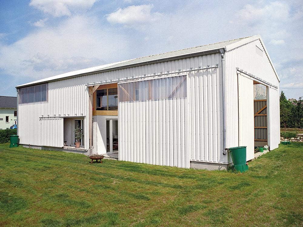 As it uses the typology of an agricultural shed the house harmonises with its village setting. Together with the architects the clients made the big doors to the shed themselves.