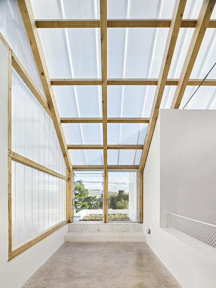 Windows of different sizes articulate the white-rendered volumes. The greenhouse constructions above the three courtyards are an essential part of the climate concept.