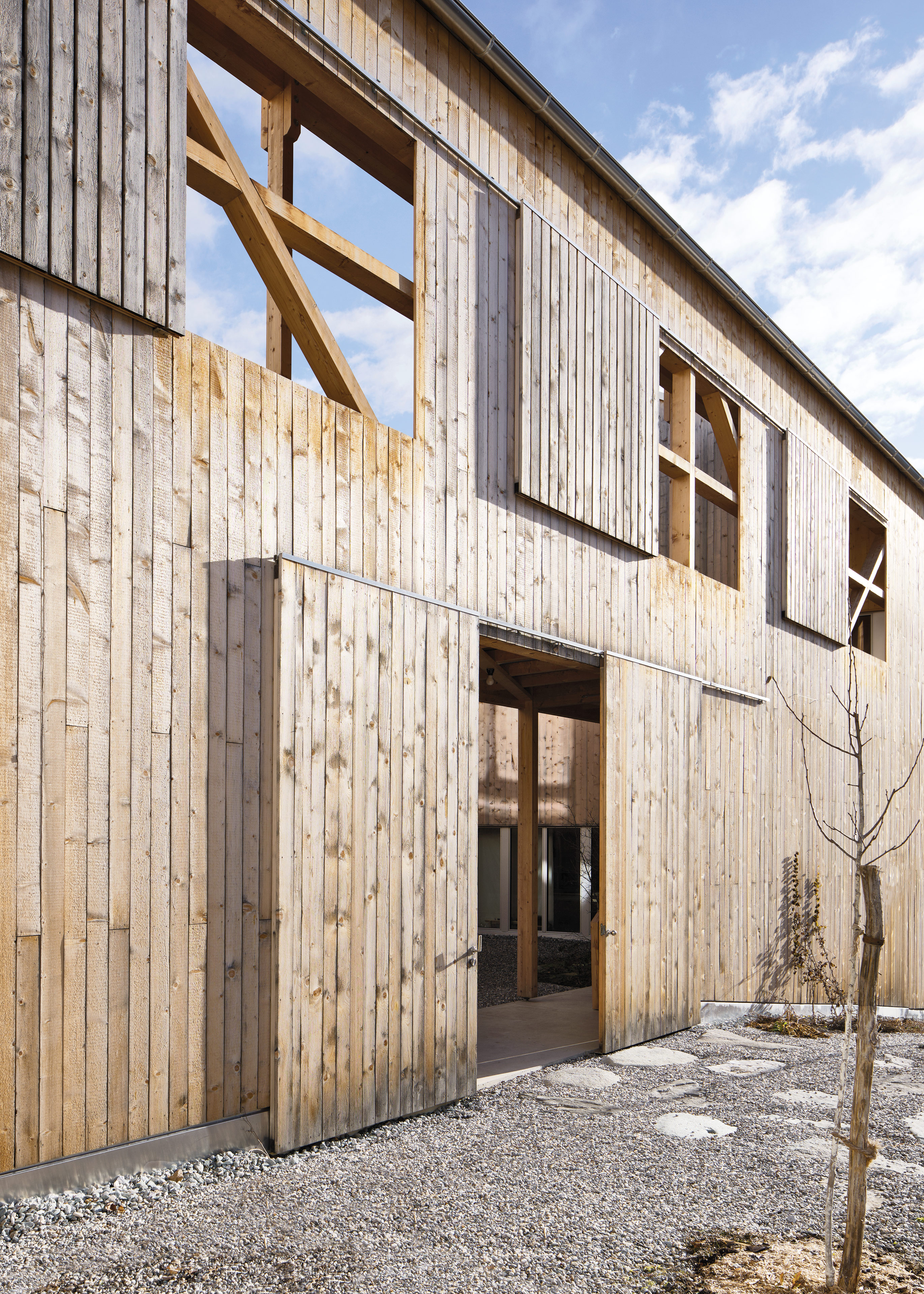 Bei geöffneten Schiebefenstern scheint Sonne in den Hof. Dann wird die kostengünstige Holzkon-struktion aus lauter gleichen Profilen sichtbar.