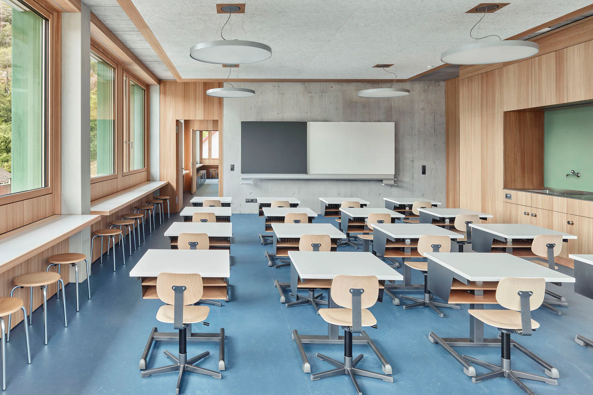 Die Klassenräume sind ideal belichtet. Die Einbauten bestehen aus Holz; die tragenden Bauteile zeigen sich in Sichtbeton.