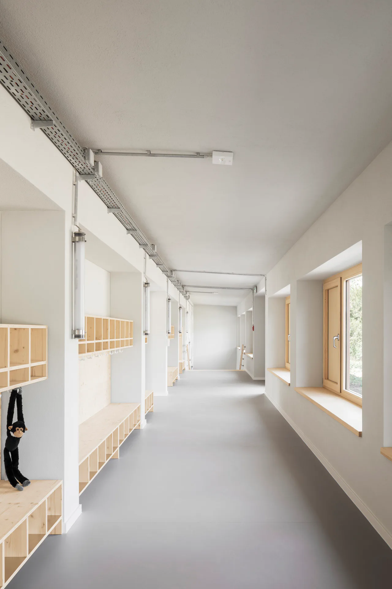 Fenster und Möbeleinbauten aus Holz bilden eine visuelle Einheit.