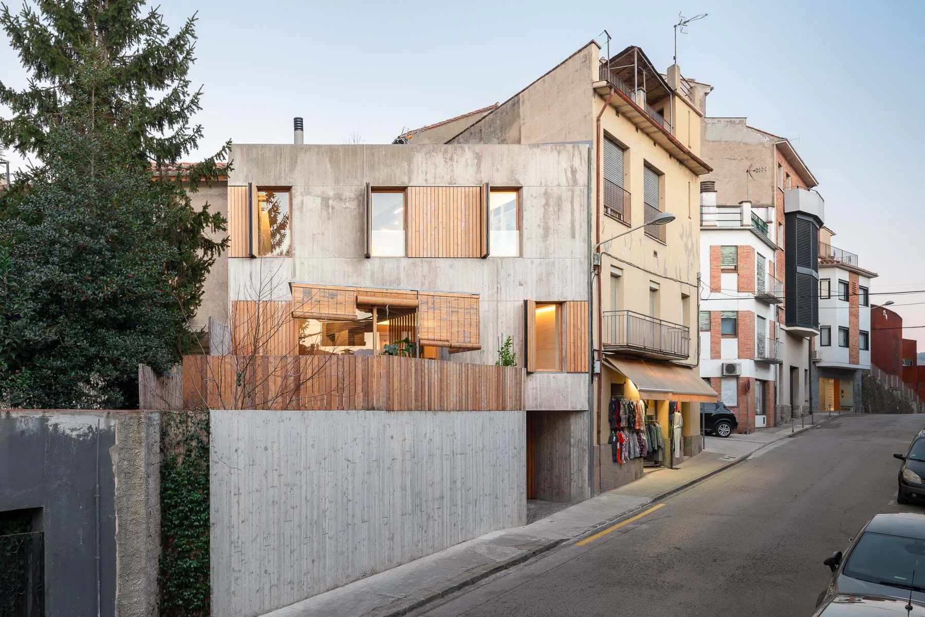 Exposed concrete and larchwood characterise the west facade of the residential building.