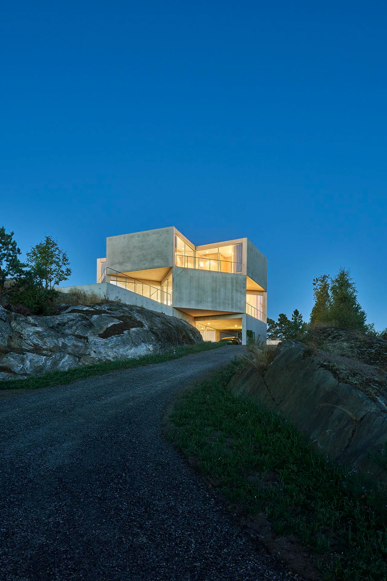 Das Ferienhaus besitzt viele verglaste Einschnitte in der Fassade, die verbleibenden Außenflächen sind mit Sichtbeton geschlossen.