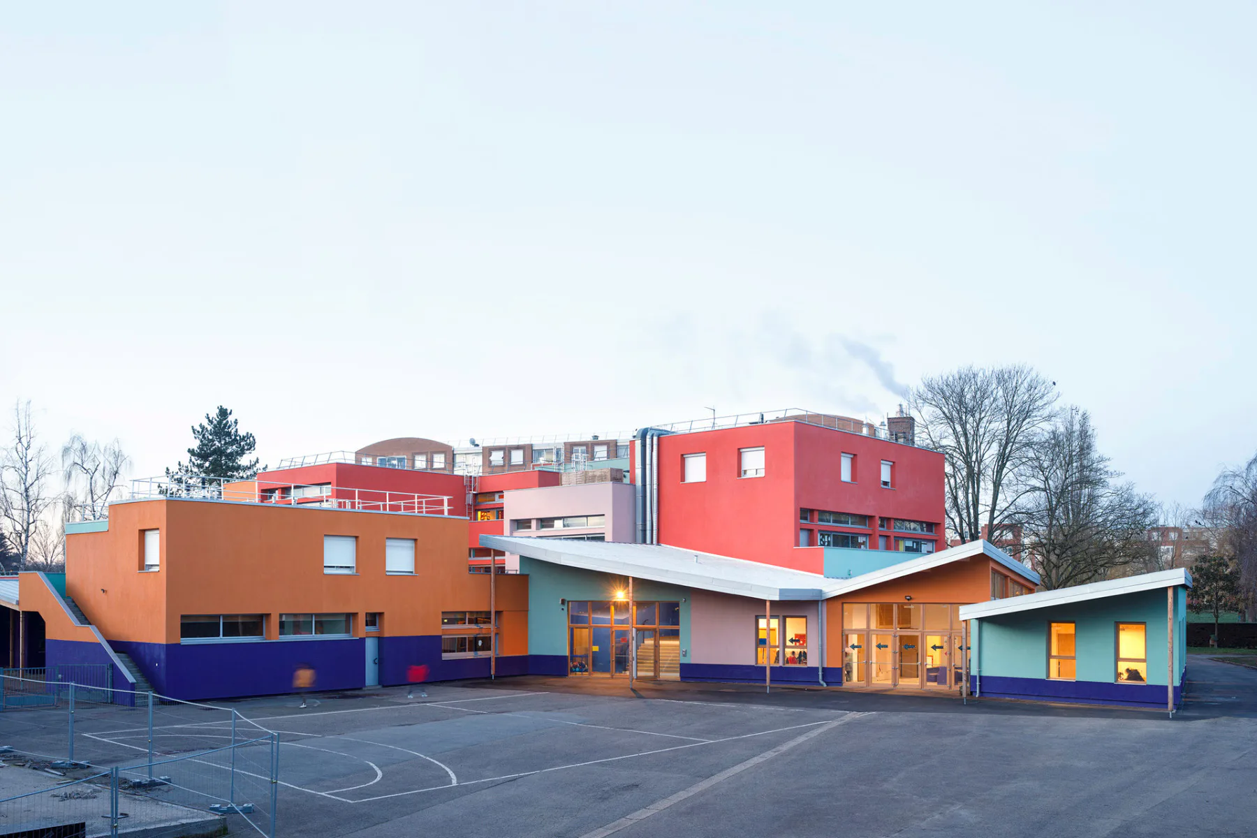 Schrägdächer kennzeichnen die baulichen Erweiterungen der von SOL Architecture et urbanisme sanierten Schule in Trappes.