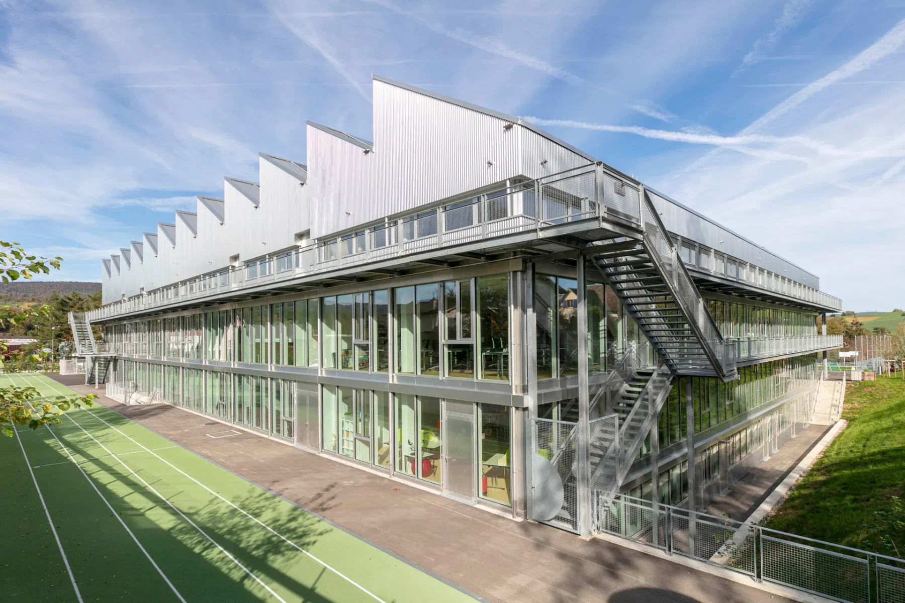 Hinter den Sheddächern verbergen sich großzügige Unterrichtsräume mit Werkstattcharakter.