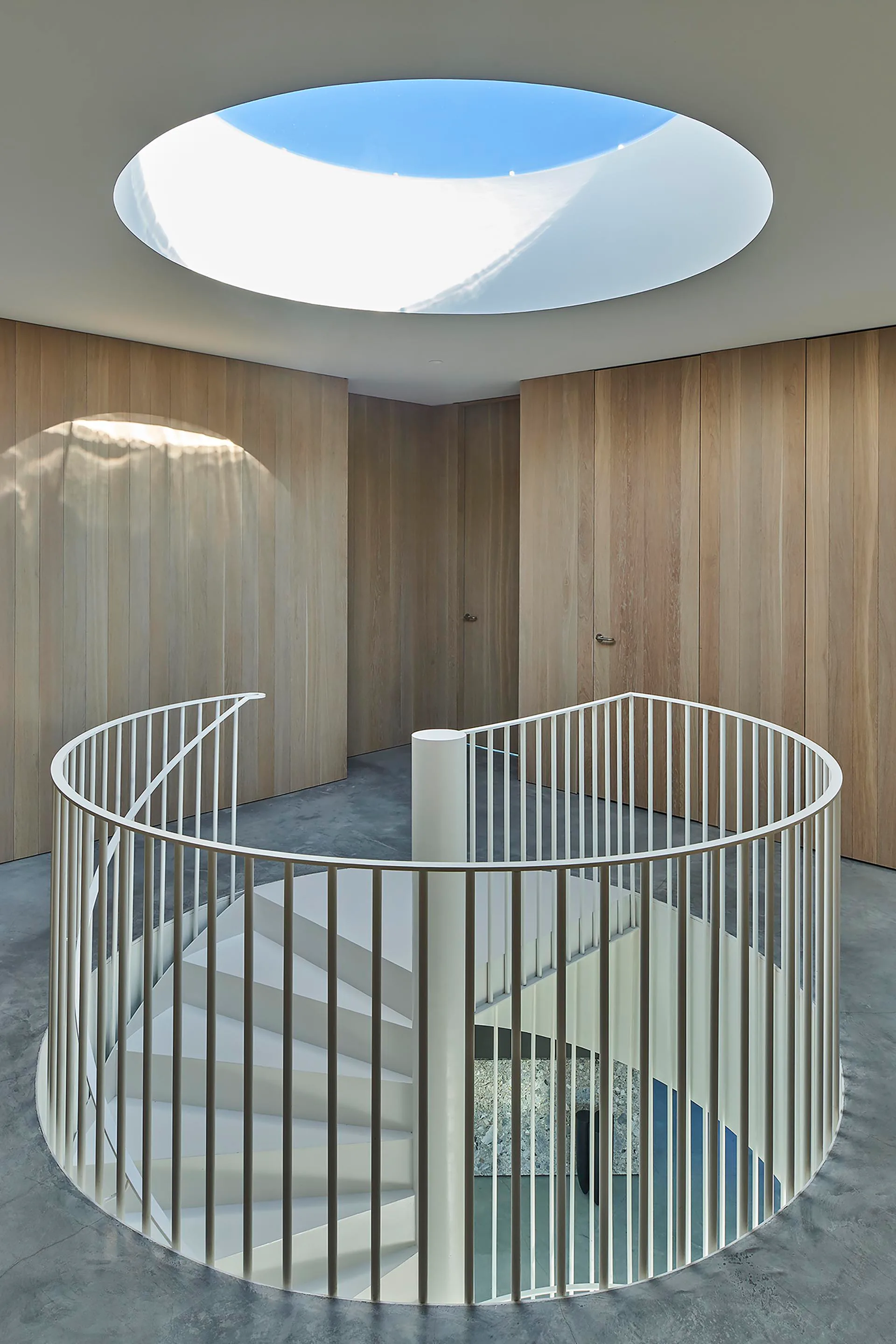 Die Wendeltreppe ist durch ein kreisrundes Oberlicht im Dach natürlich belichtet.