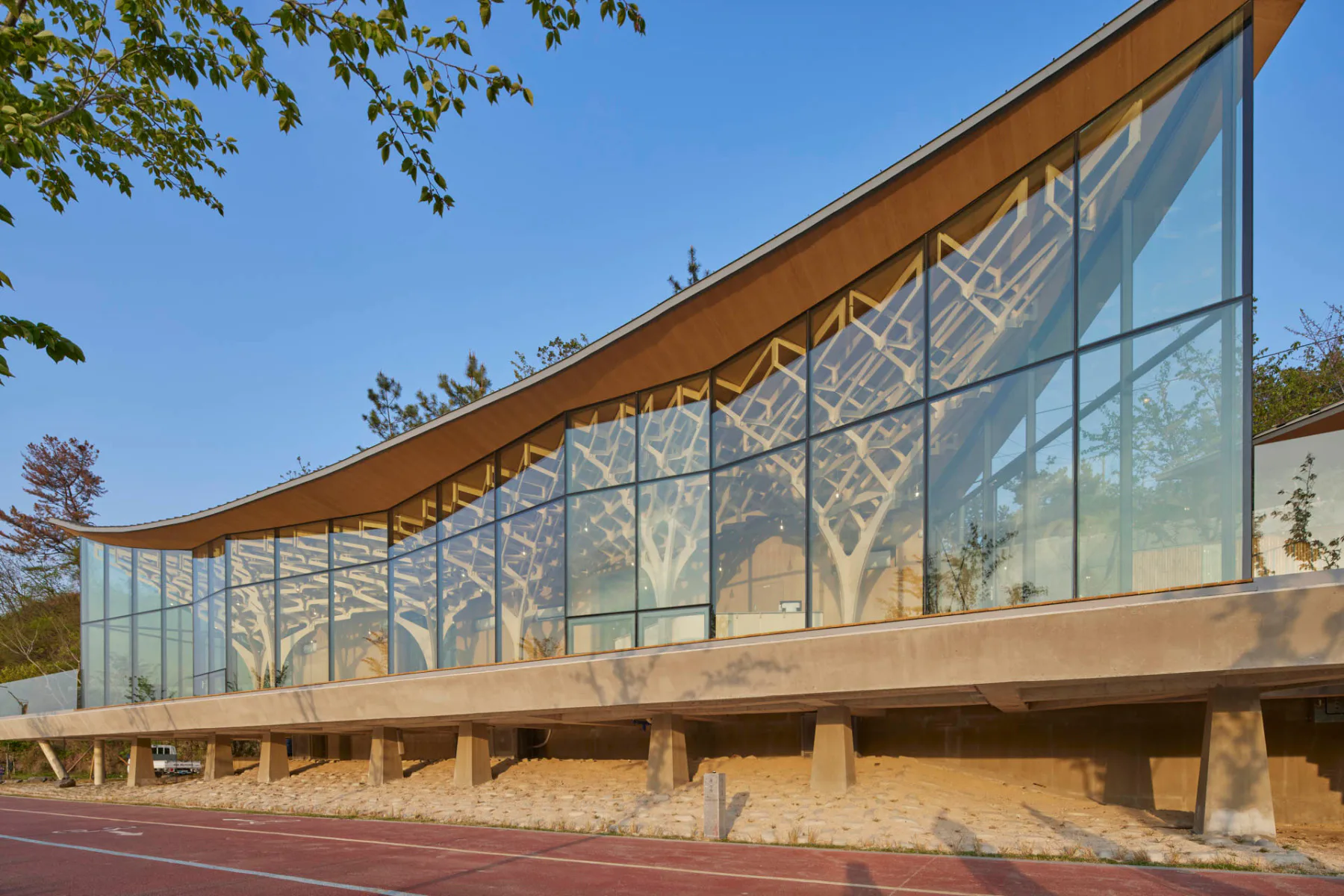 Ein mächtiger Betontisch trägt den Pavillon, der mit seiner Glasfassade und den Holzstützen ausgesprochen leichtgewichtig daherkommt.