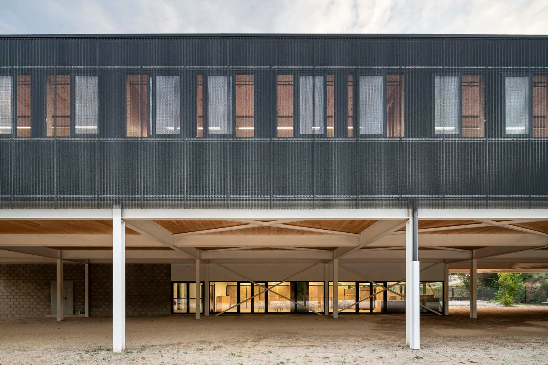 Holz, eine schwarze Dichtungsfolie und das weiße Stahltragwerk kontrastieren miteinander.