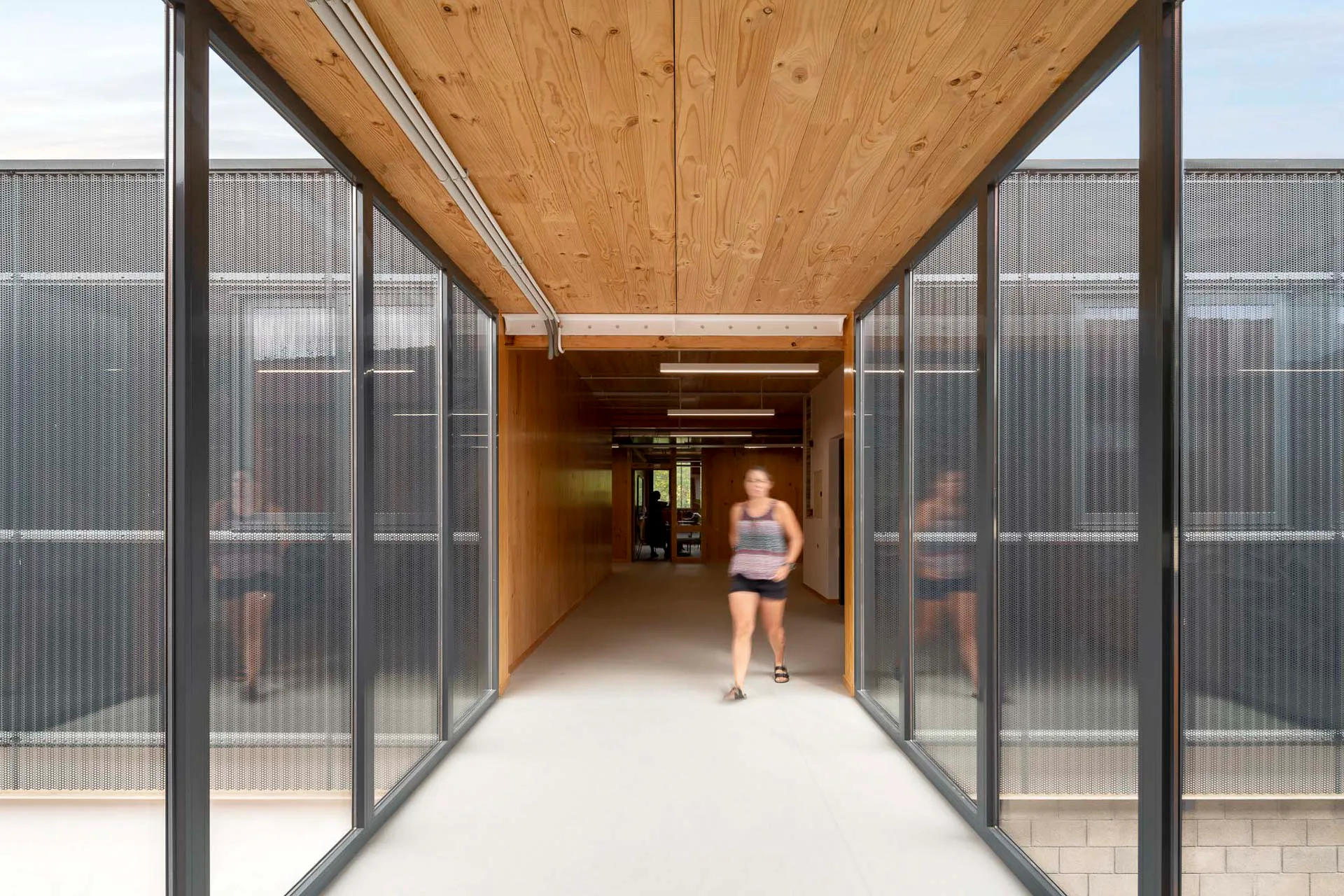 A pedway links the addition to the existing structure of red masonry.