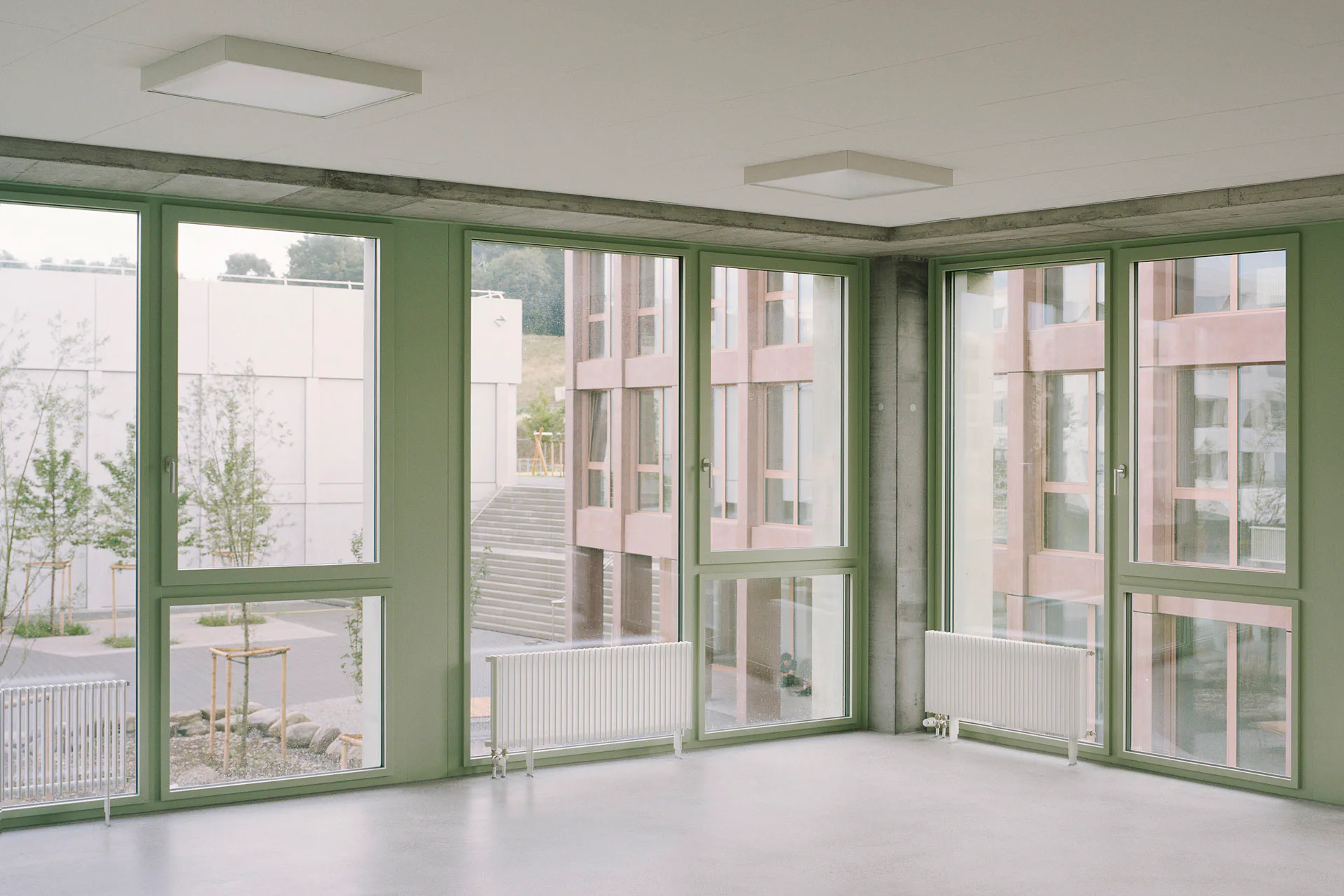 The pink, green or grey window frames add a touch of colour to the minimalist interiors.