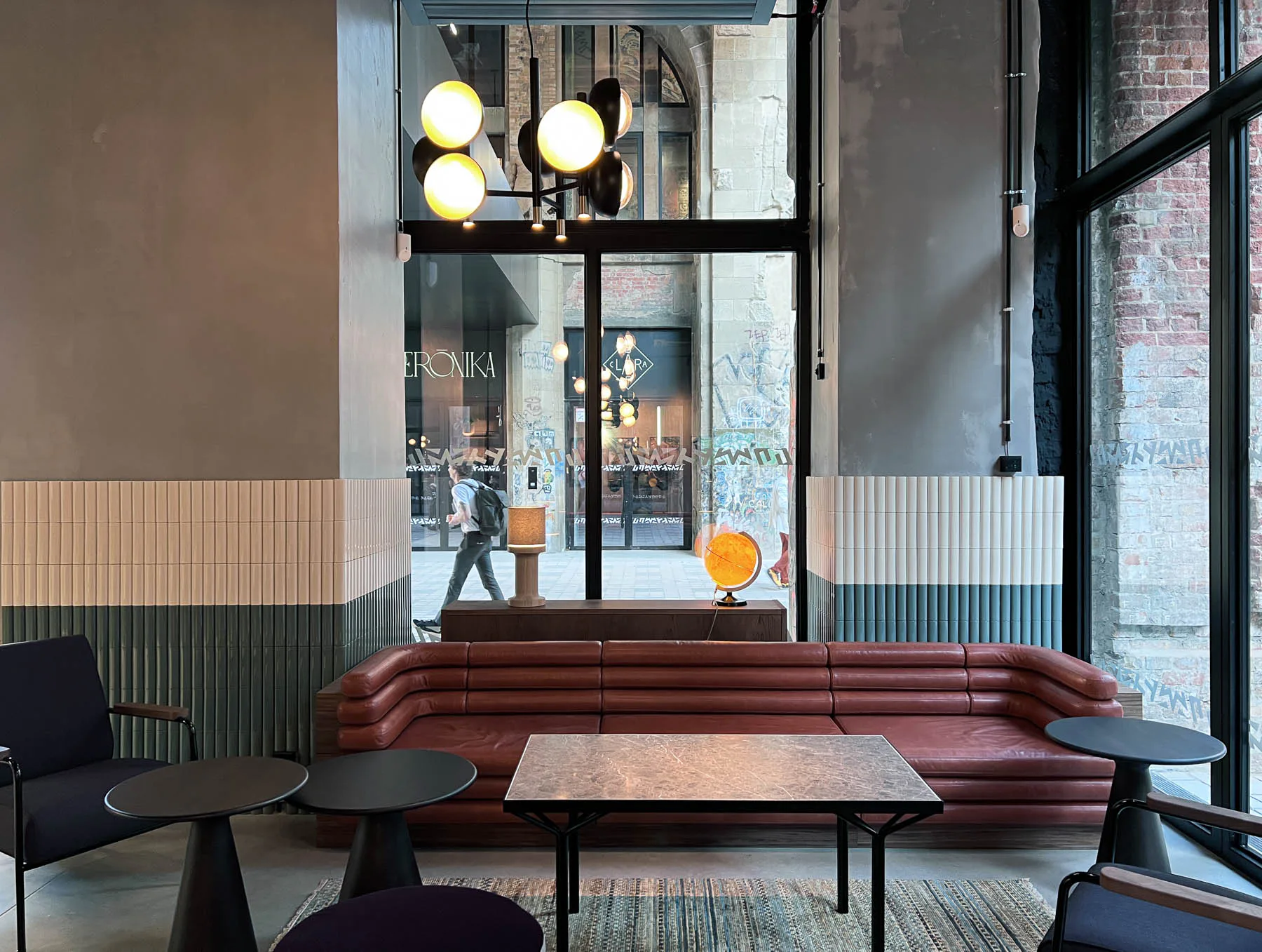 Gewellte Keramikfliesen und mit Leder und Samt bezogene Sitzbänke prägen das Interior der CaféBar.