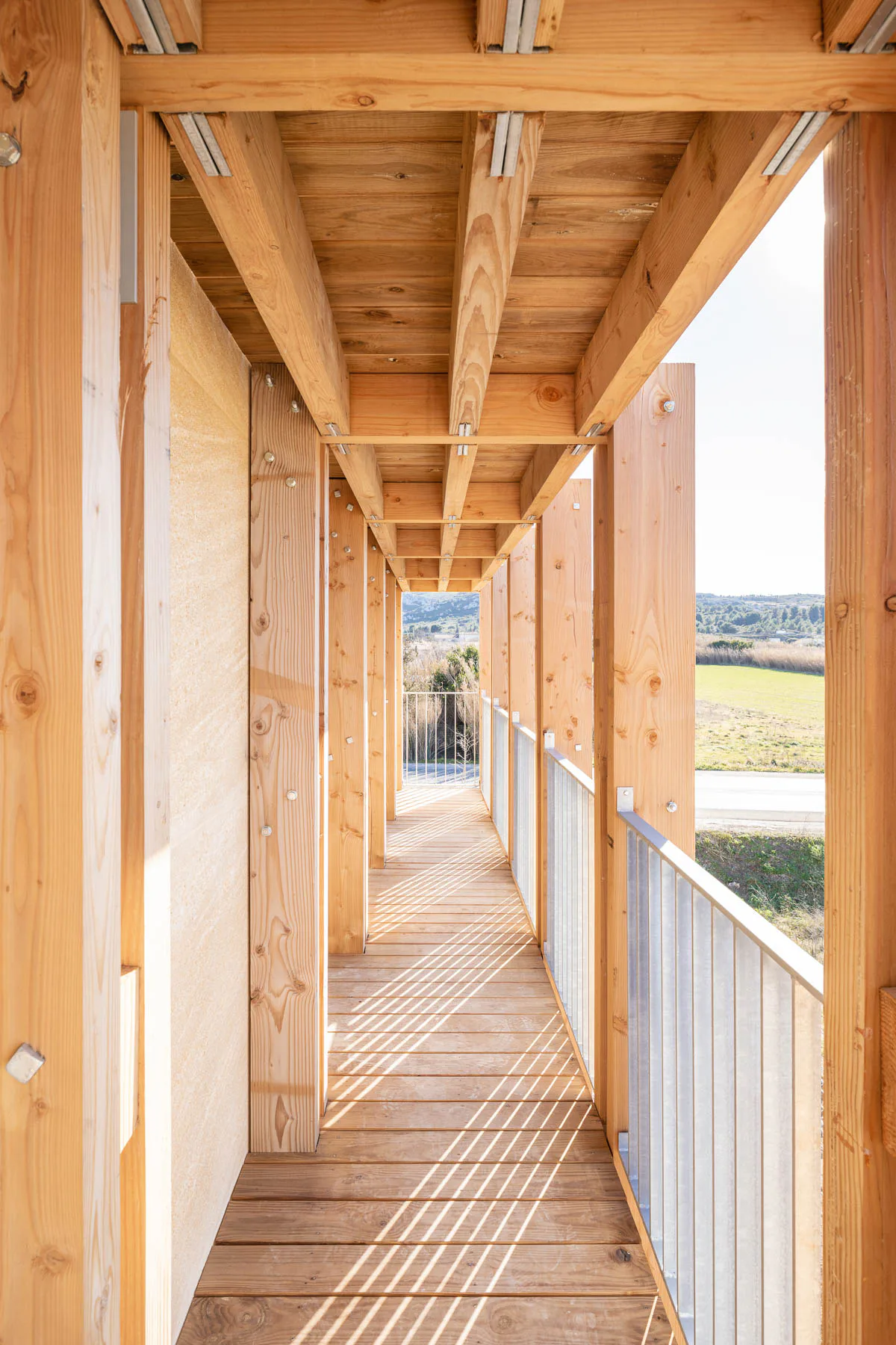 Leichte, vorgelagerte Holztragwerke ergänzen die massiv wirkenden Wohnbauten.