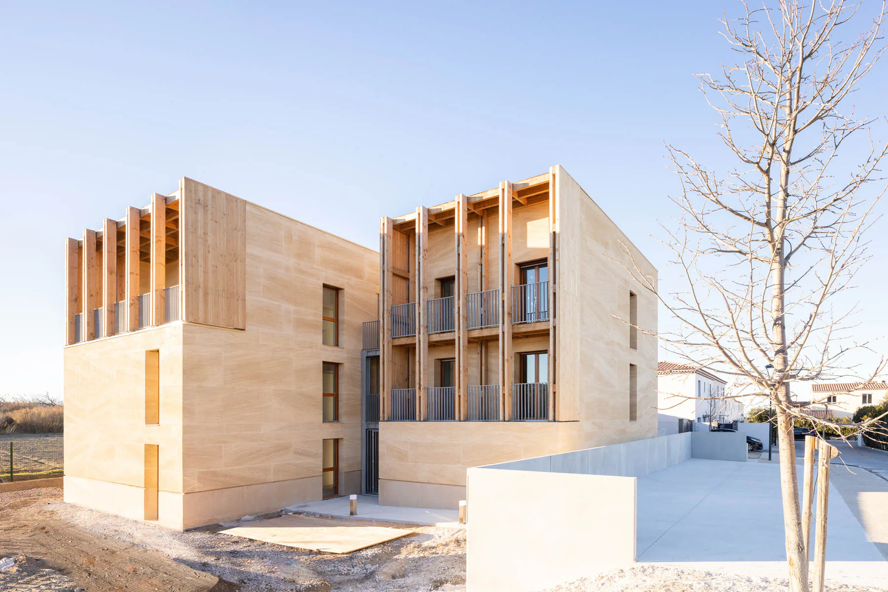 Für ein soziales Wohnbauprojekt mit acht Einheiten kombinierte Atelier Régis Roudil Beton und Stein mit Holz.