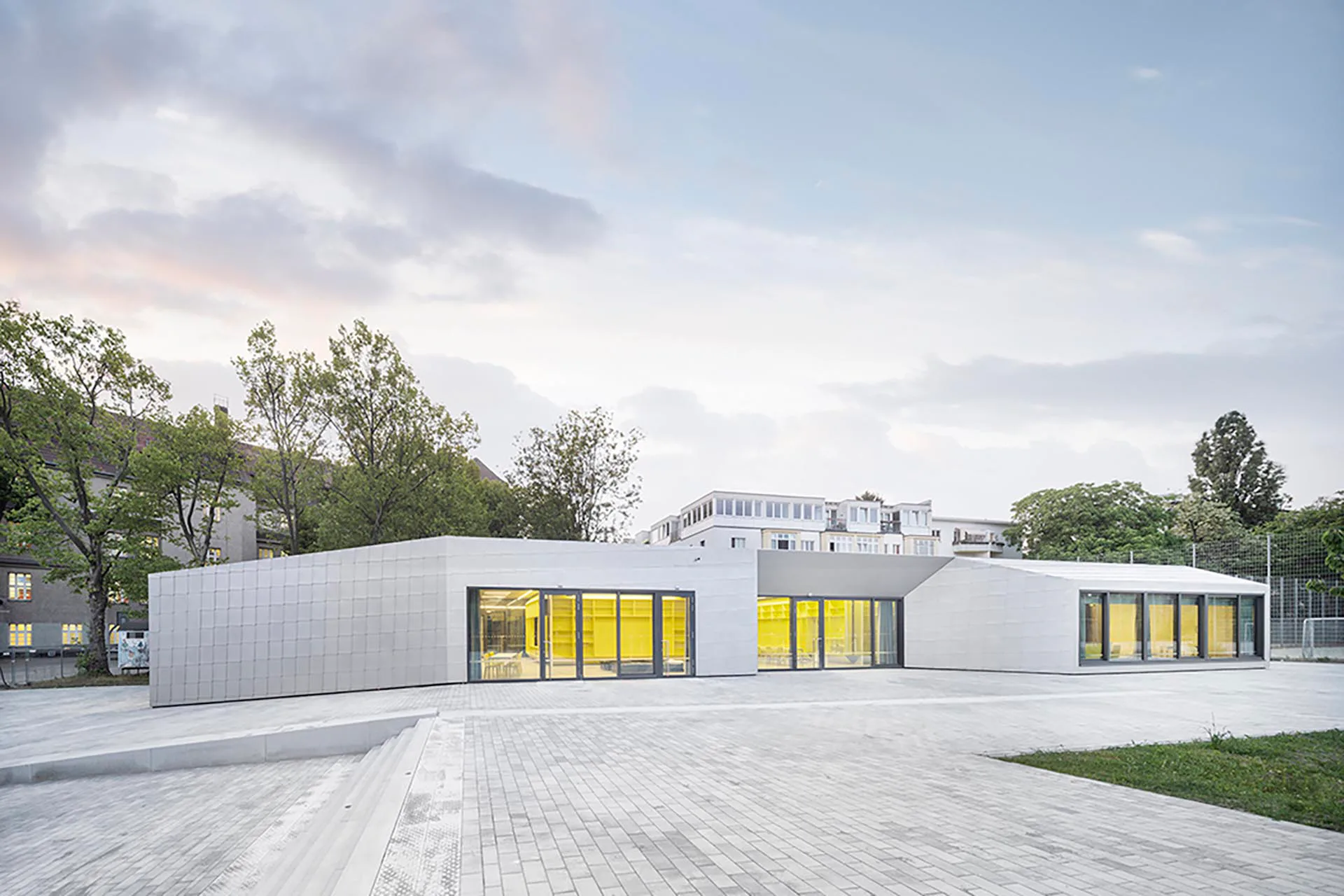 Mit zahlreichen Ausstülpungen öffnet sich der eingeschossige Neubau zum Hof. Rechte Winkel gibt es dabei kaum.