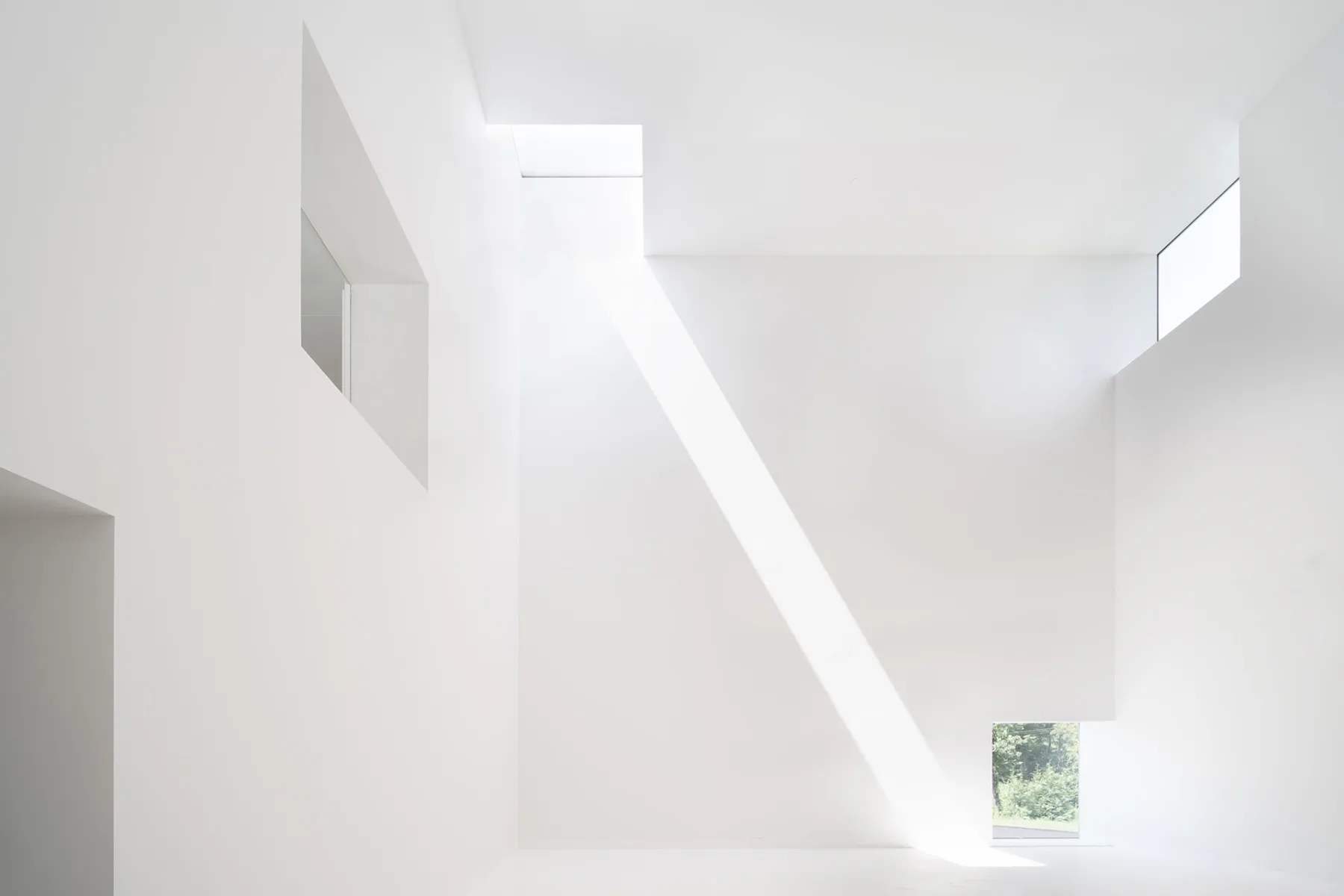 Der Saal für die Wechselausstellungen ist ein perfekter Kubus. Sechs quadratische Öffnungen mit 2,10 m Kantenlänge öffnen ihn nach draußen und zu den Nachbarräumen.