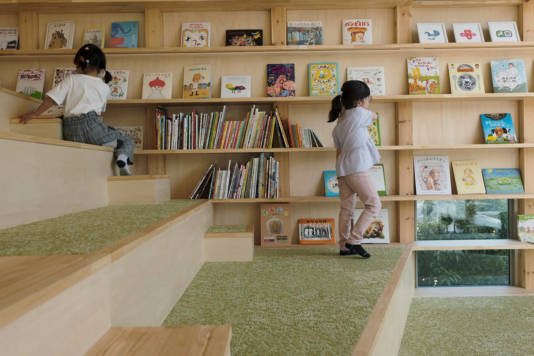 Große Holzstufen mit angrenzenden Bücherregalen laden die Kinder zum Lesen ein.
