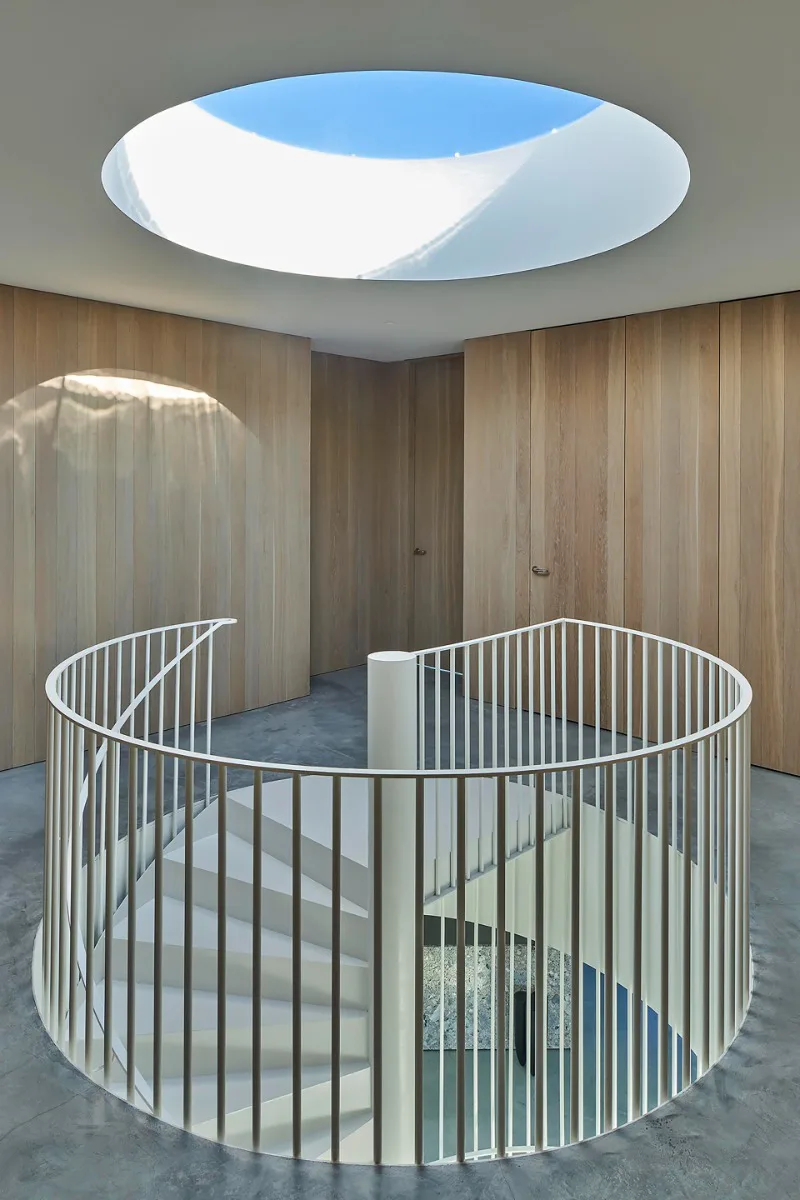 Die Wendeltreppe ist durch ein kreisrundes Oberlicht im Dach natürlich belichtet.