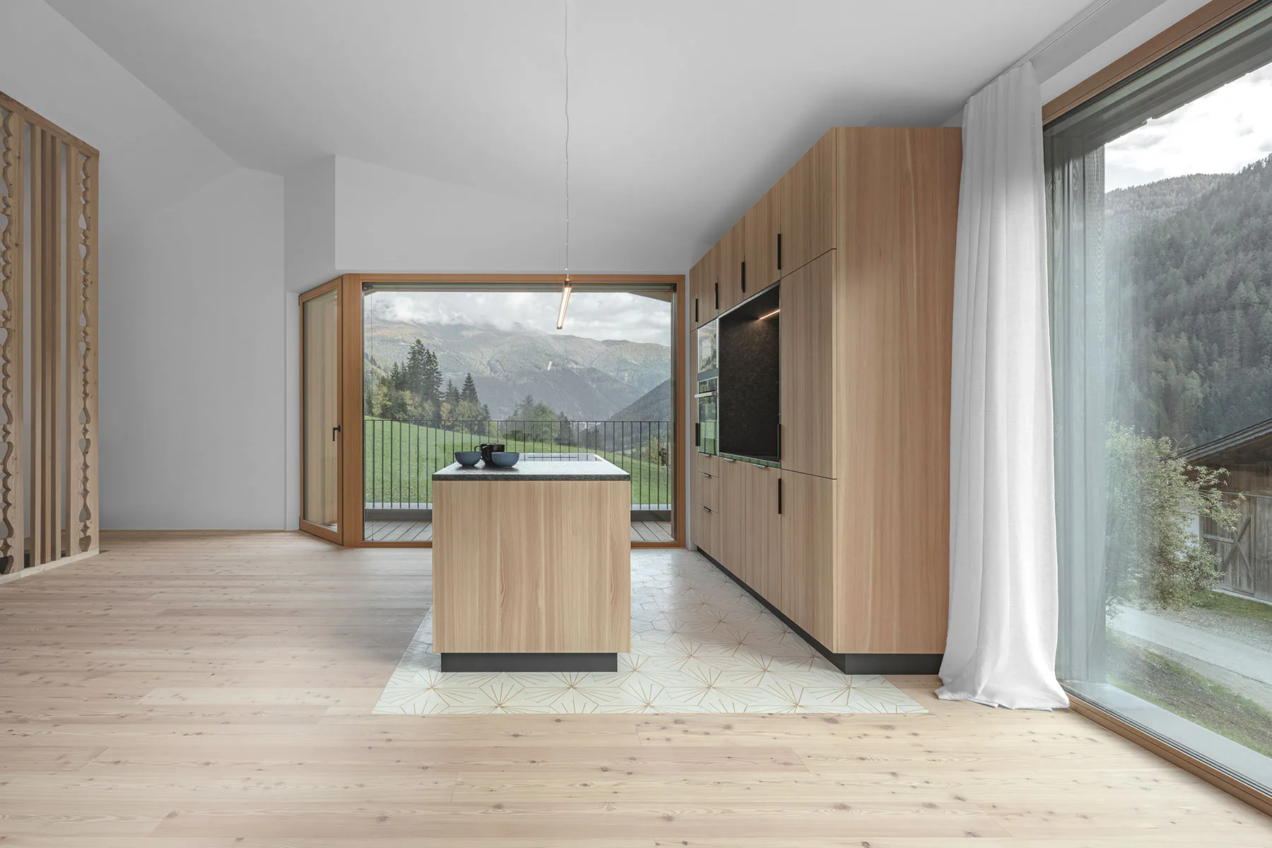 Lärchenholz und eine traditionellere Ornamentik kennzeichnen die Wohnräume des unteren Hauses.
