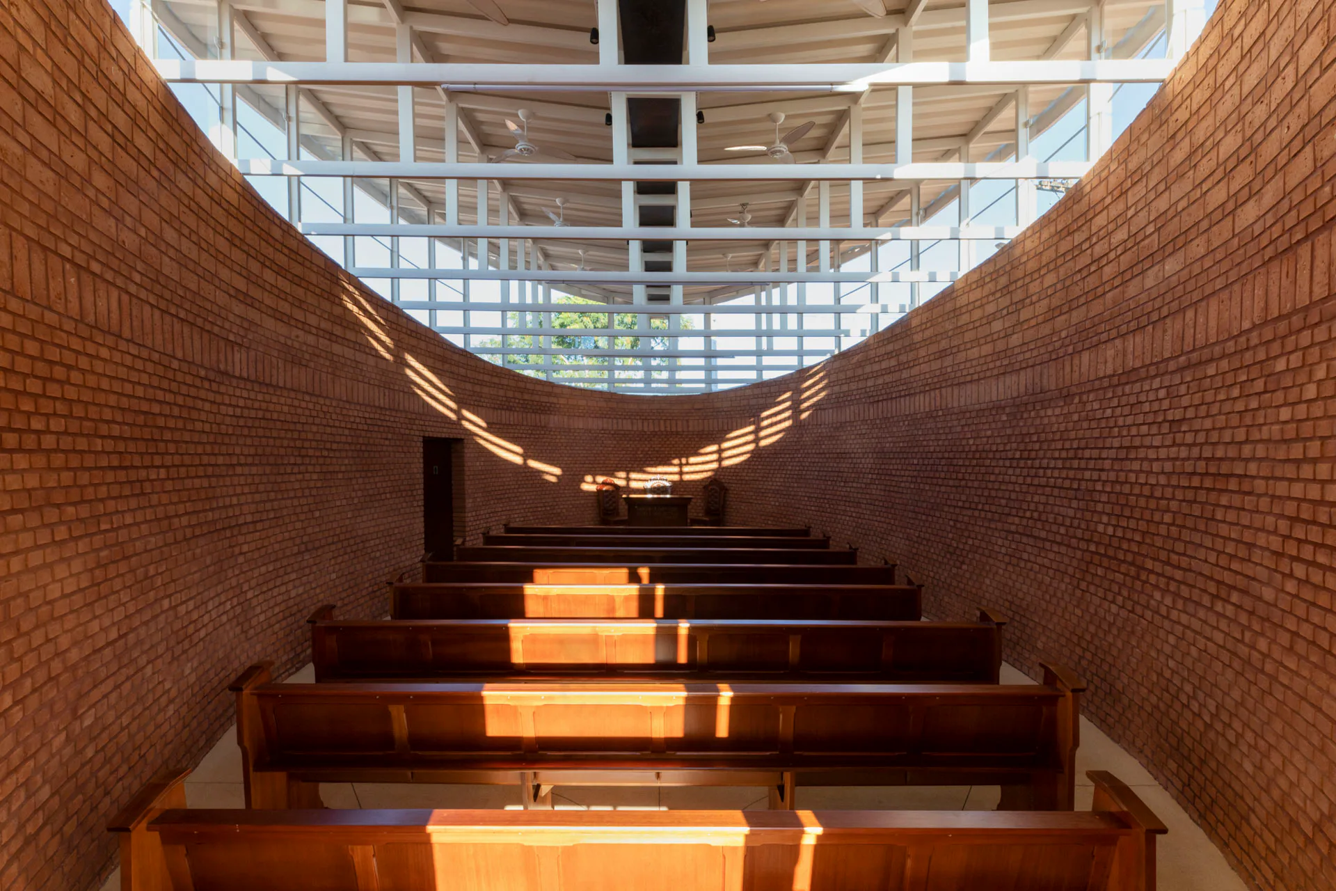 Die Kirche fasst etwa 70 Personen. Tageslicht fällt durch Oberlichtbänder zwischen Dach und Außenwänden in den Raum.