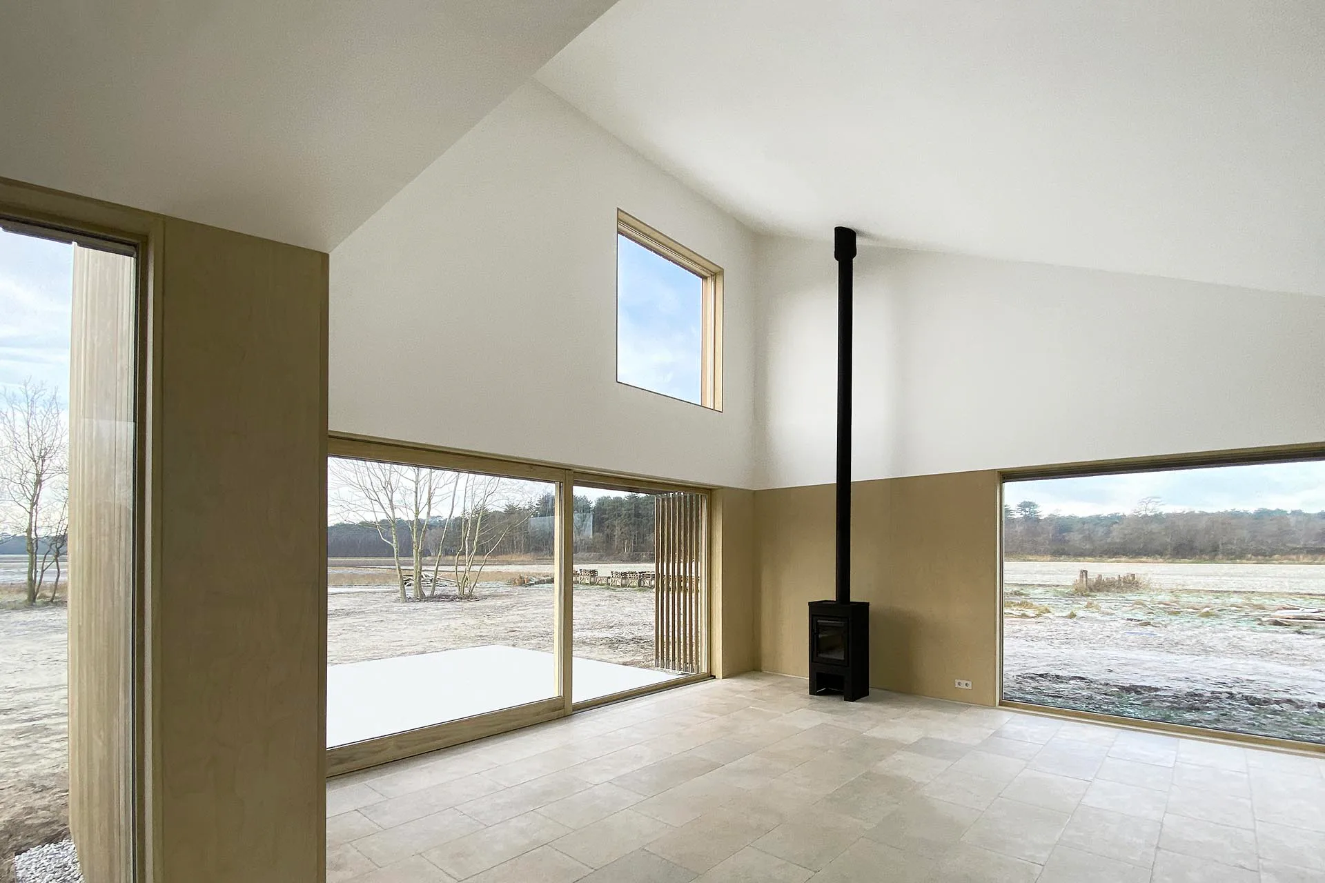 Große Fenster und Schiebetüren bringen Licht in die Wohn- und Praxisräume.