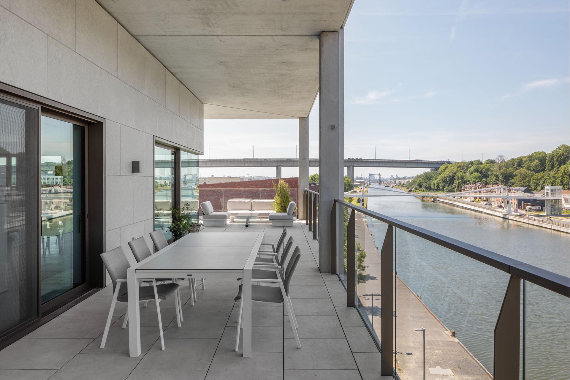 Eckwohnung mit Kanal- und Autobahnblick. Die Fassaden sind mit grauem Kalkstein verkleidet.
