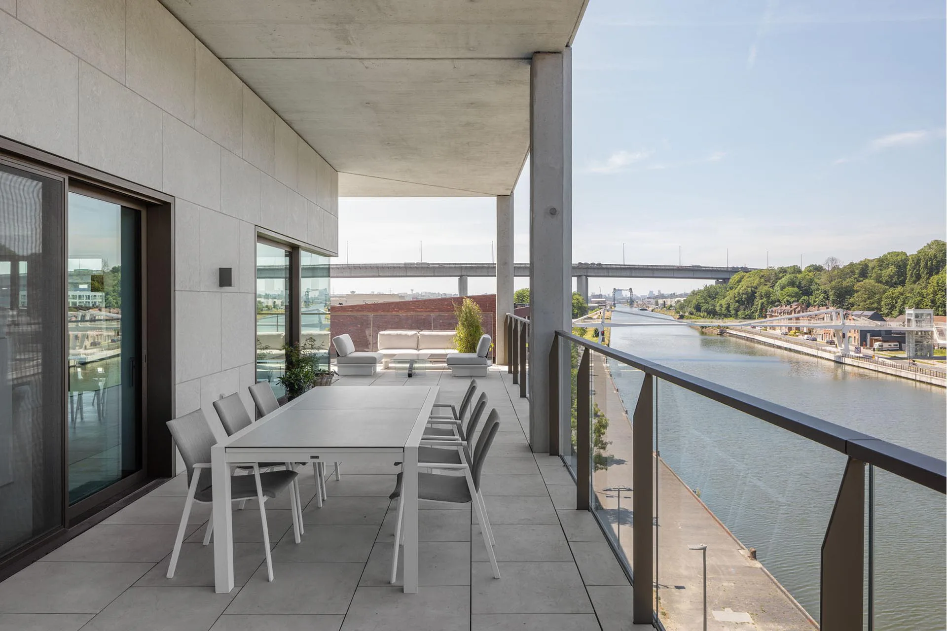 Eckwohnung mit Kanal- und Autobahnblick. Die Fassaden sind mit grauem Kalkstein verkleidet.