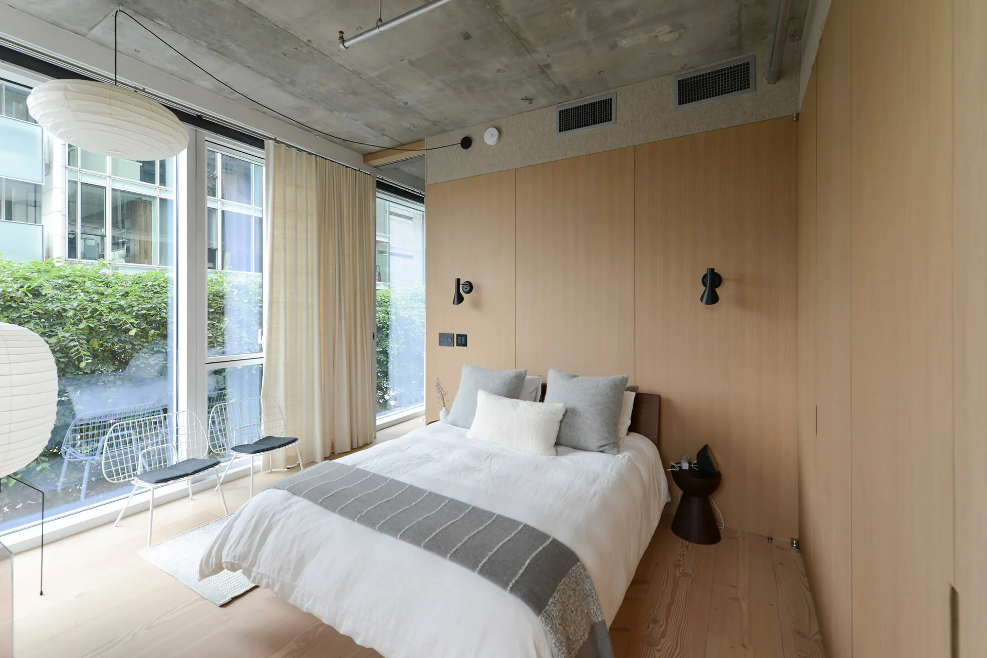 Die Schlafzimmer wurden als eingestellte Nischen entworfen; weiße Vorhänge schützen vor neugierigen Blicken.