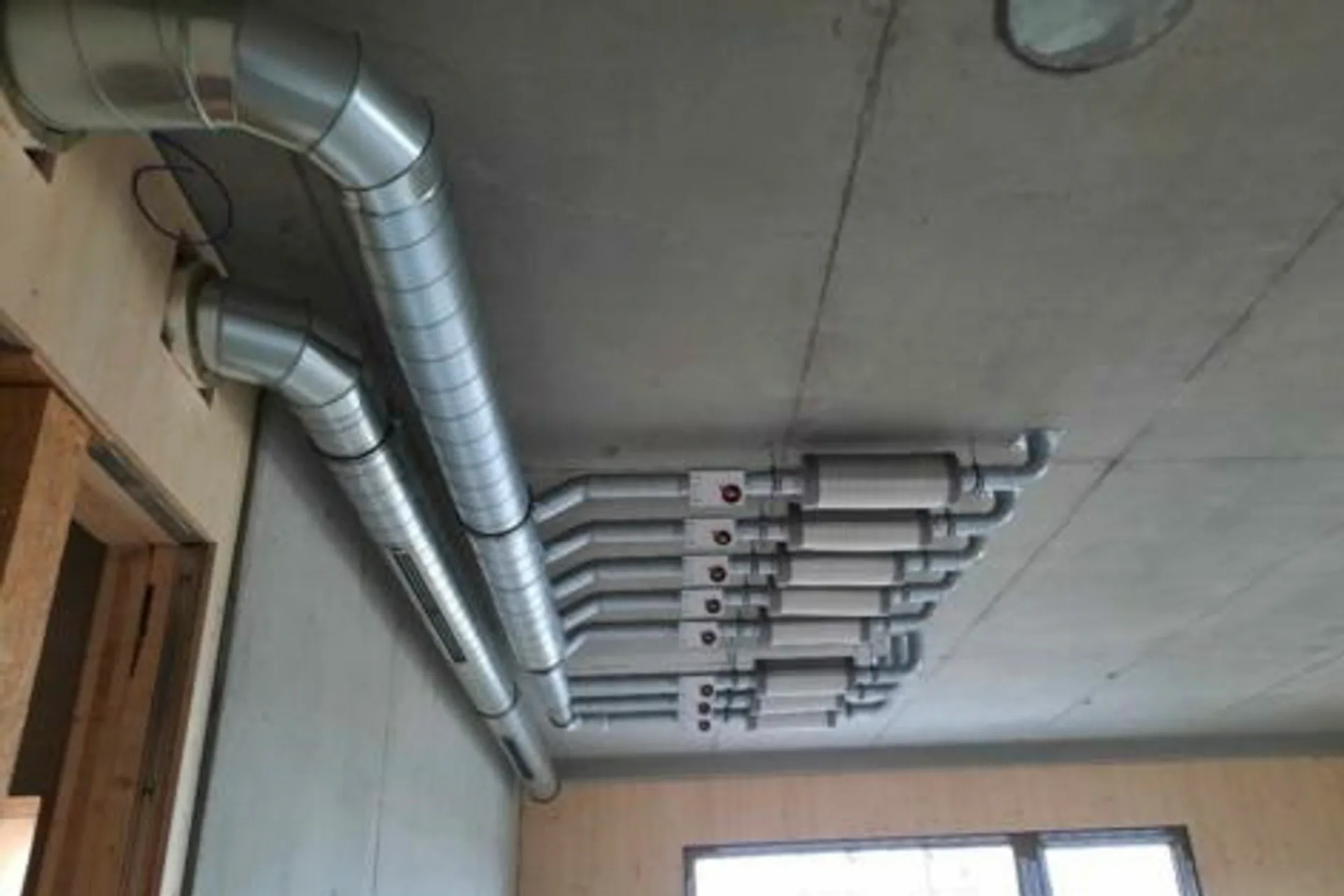Concretcool ermöglicht glatte Deckenansichten, die Kiefer-Luftauslässe sind flächenbündig in die Betondecken integriert.