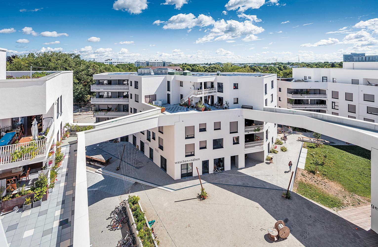 Beim Genossenschaftsbau Wagnis Art sind die fünf Häuser im 3. Obergeschoss durch Brücken zu einer Gemeinschaftsterrasse mit Alpenblick verbunden.